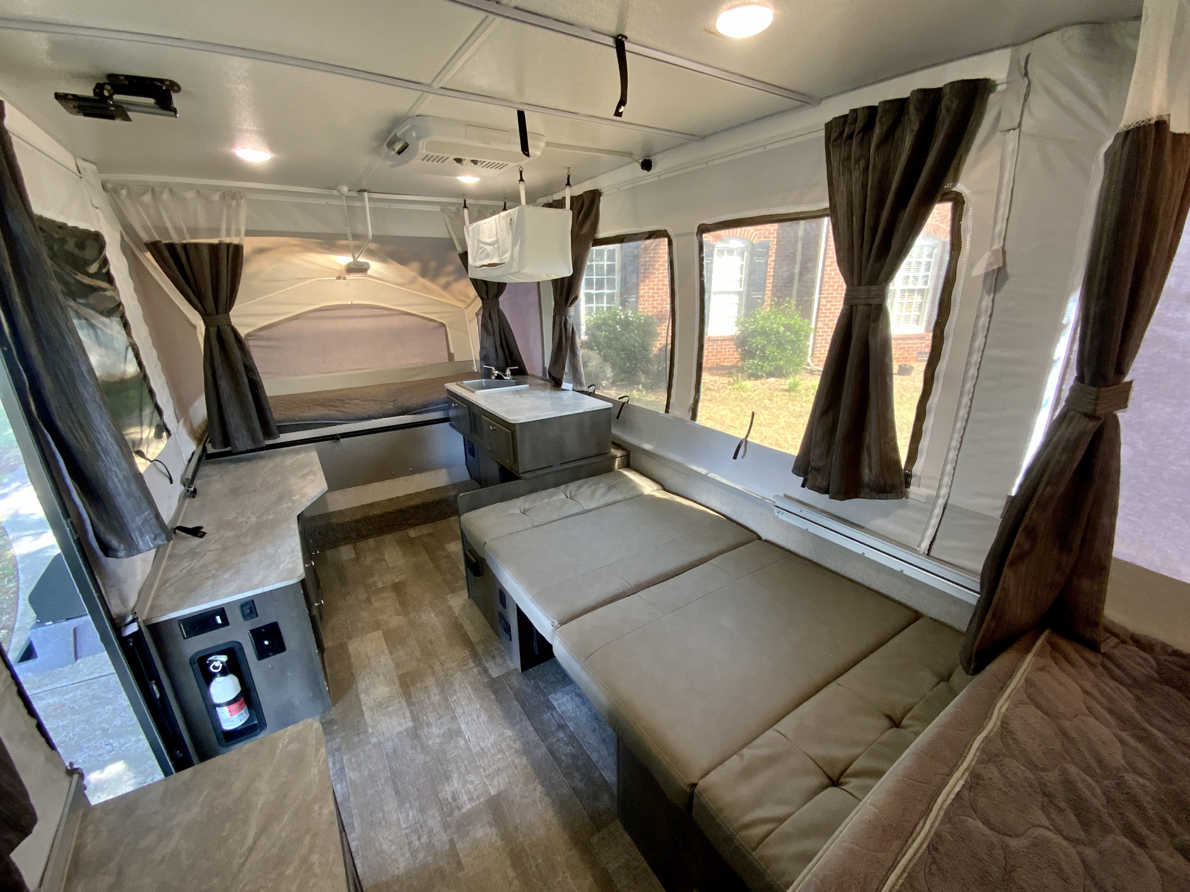Bright and airy pop-up camper RV rental interior, featuring beds, a dinette, and a compact kitchen setup.. Forest River Rockwood Freedom 2020