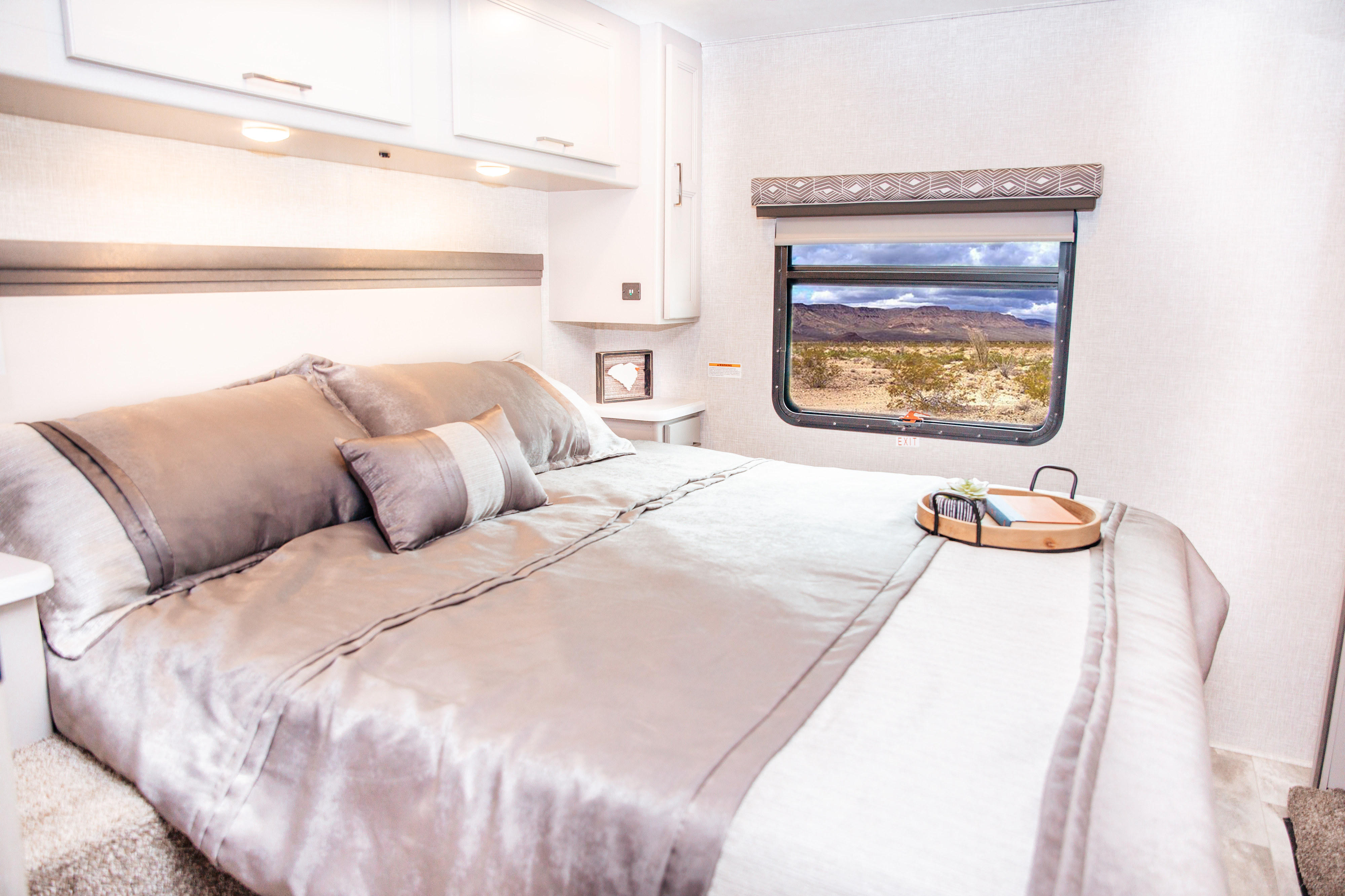 Comfortable RV rental bedroom with a scenic desert view from the window. Perfect for your next adventure.. Thor Motor Coach Windsport 2022