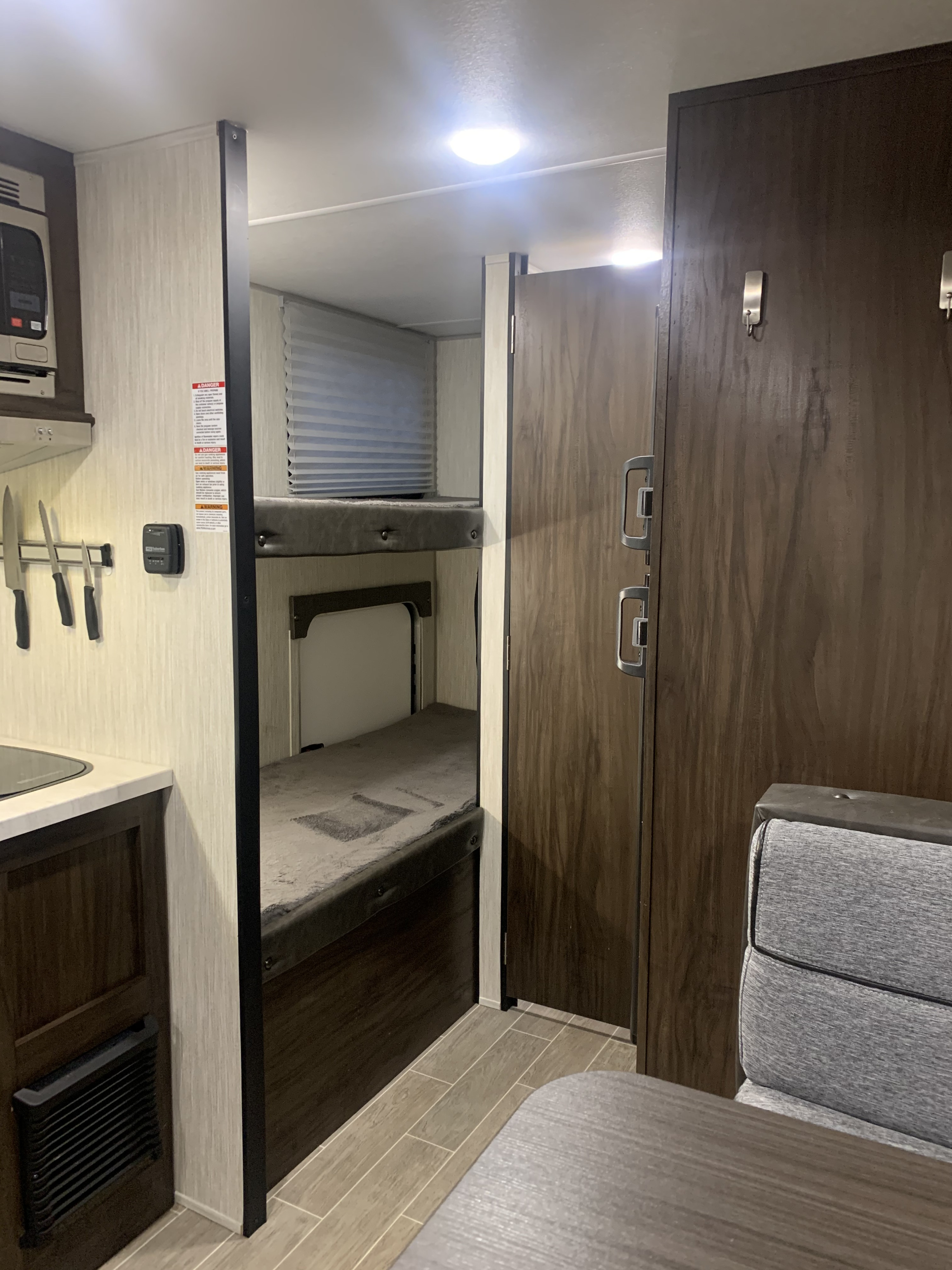 An RV rental interior reveals a compact kitchen, bunk beds, and a dinette, offering functional living amenities.. Forest River Patriot Edition 2020