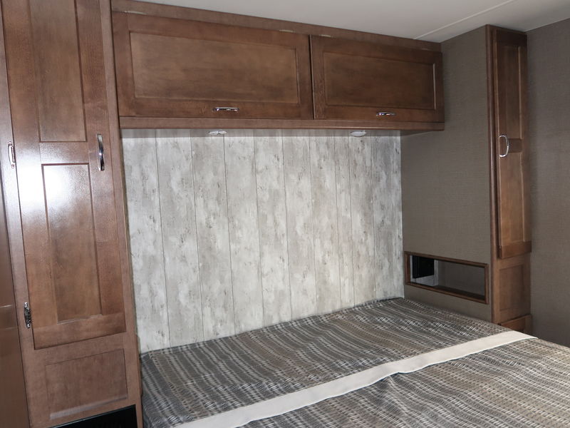 RV rental bedroom with overhead storage, a comfortable bed, and compact cabinets for travelers.. Winnebago Winnebago 2020