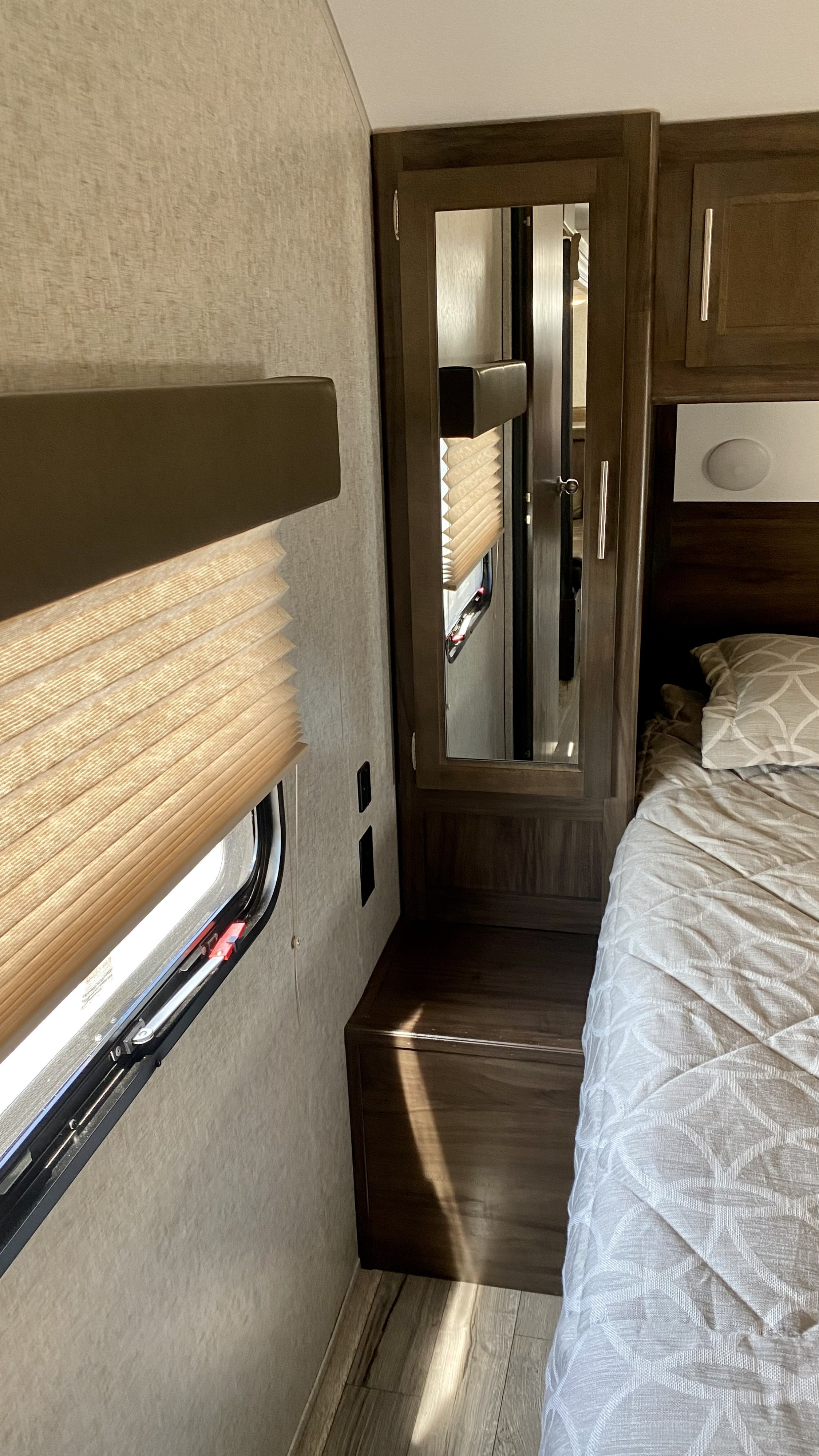 RV rental interior: bedroom with pleated window blinds, built-in mirrored wardrobe, and comfortable bed.. Forest River Cherokee Grey Wolf 2019