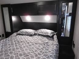 Inside an **RV rental**: a modern bedroom with a comfortable bed, overhead storage, and mirrored closets. Ideal for your next trip.. Forest River Cherokee Grey Wolf 2021
