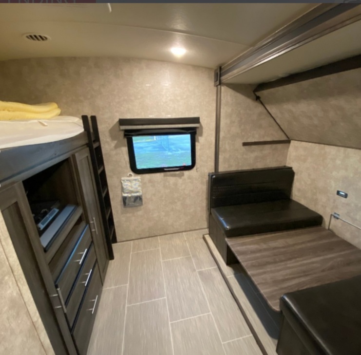 This RV rental interior features a bunk bed, ladder, storage, a window, and a convertible dinette area.. Open Range Open Range 2018