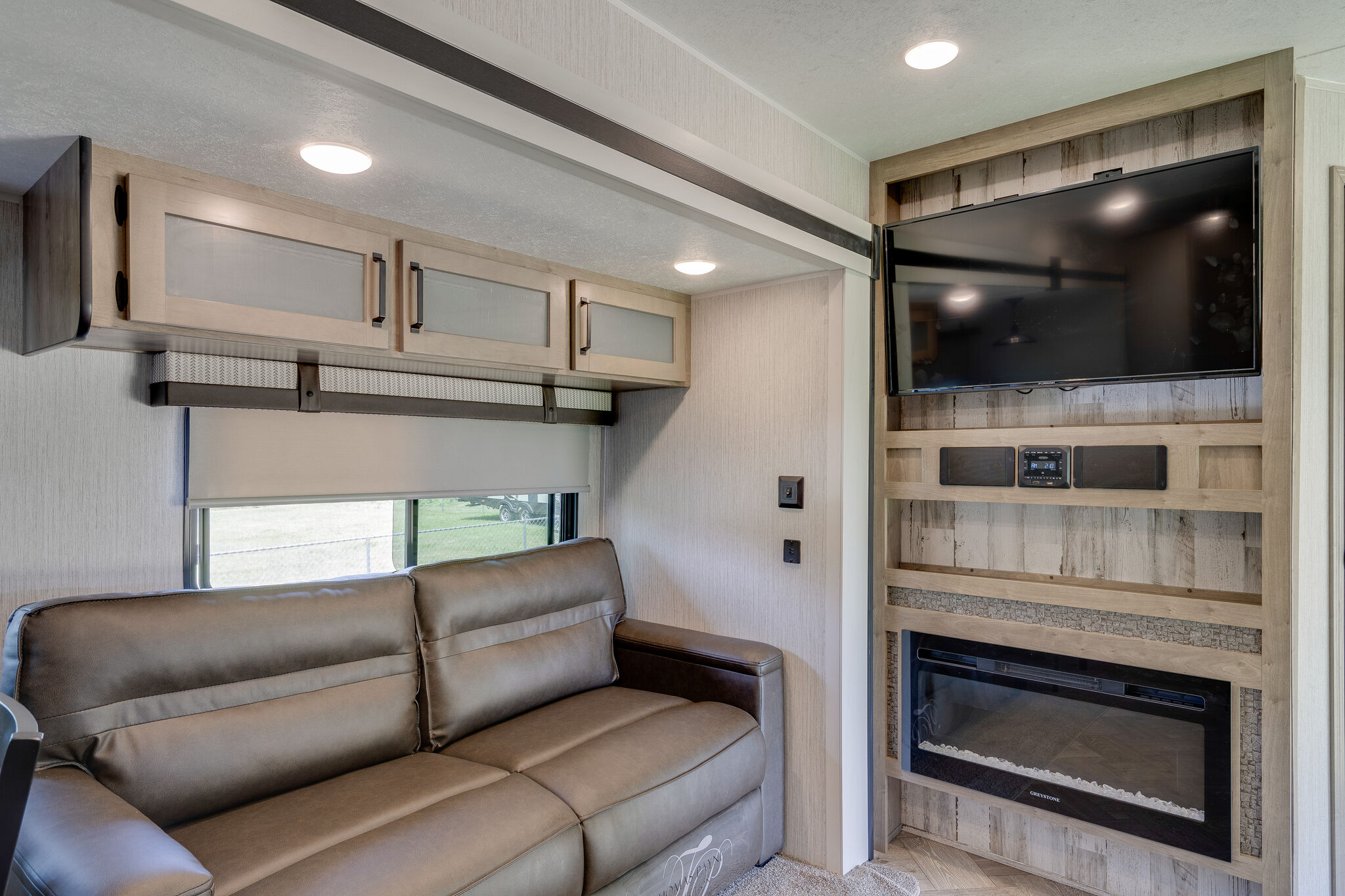 This cozy RV rental features a spacious sofa, flat-screen TV, electric fireplace, and ample overhead cabinets for comfort on the road.. Palomino Puma Park Trailer for Temporary Housing 2021