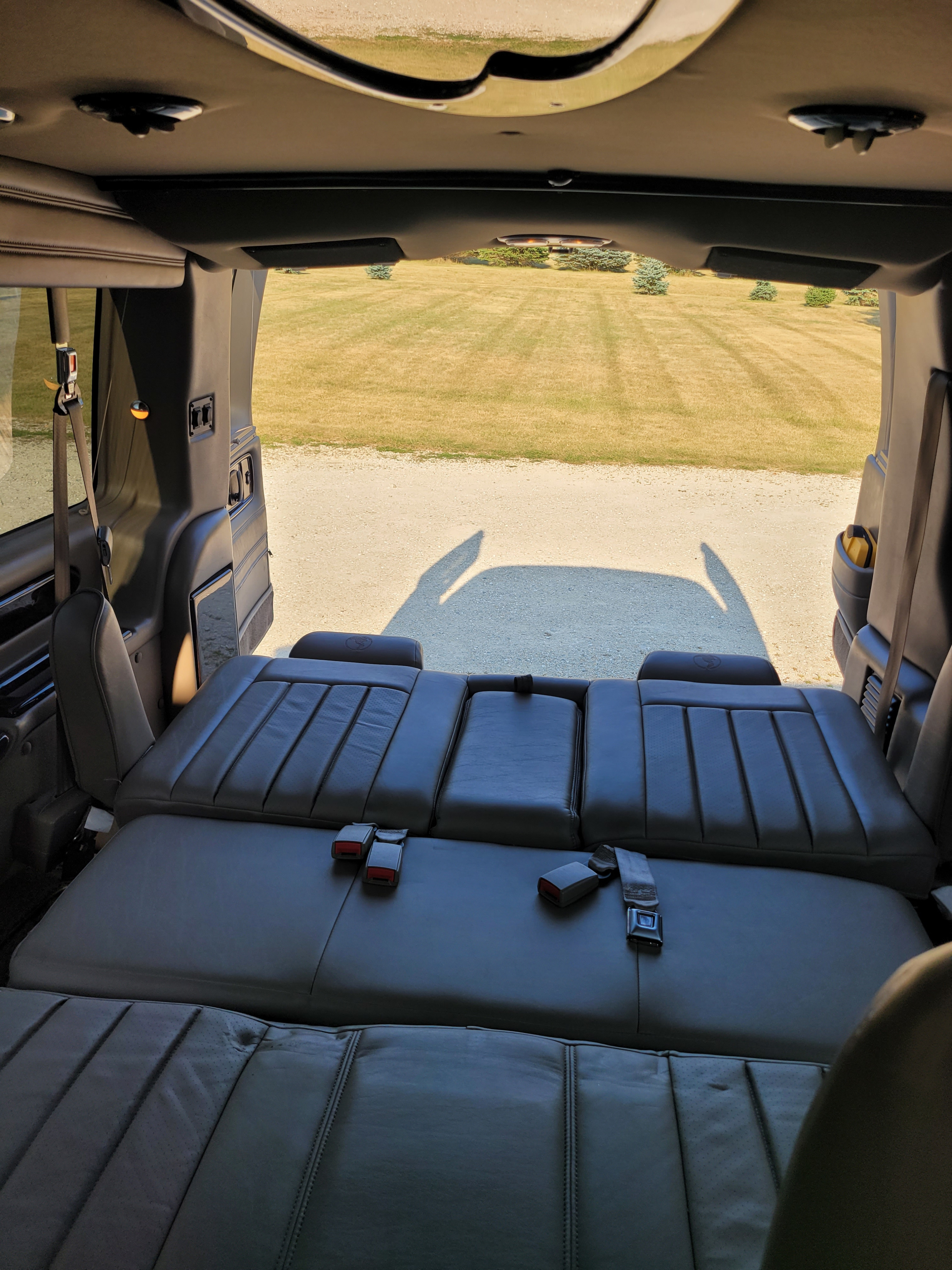 Explore comfort in this **rv rental**! View of grass/gravel from the interior featuring versatile leather seats converting to a bed.. Chevrolet Express 2012