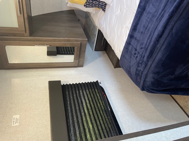 Step into comfort: This RV rental bedroom features a cozy bed, built-in storage with a mirror, and window blinds for privacy.. Dutchmen Coleman 2021