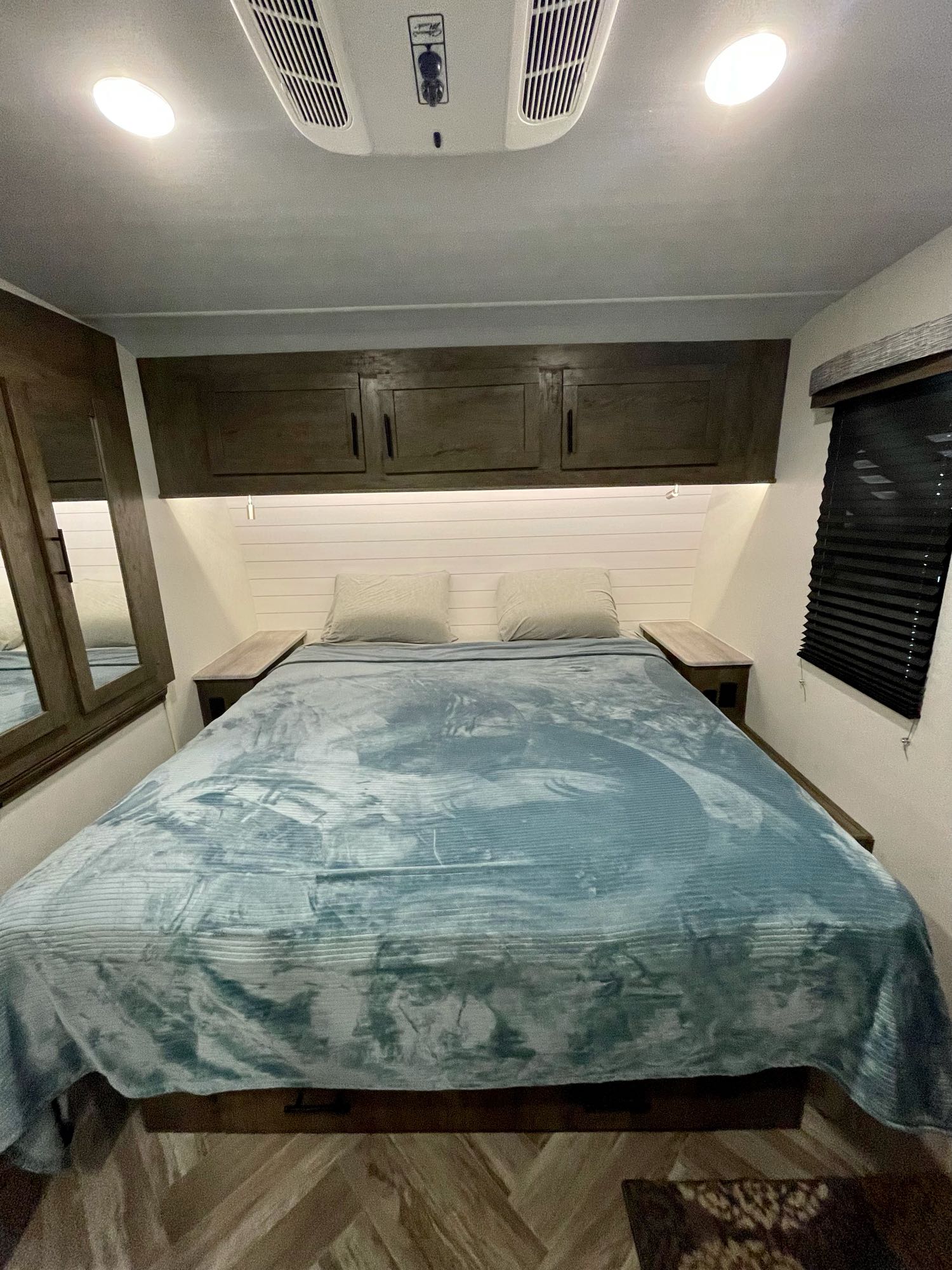 Cozy RV rental bedroom with comfortable bed, overhead storage, and modern amenities, perfect for travel adventures.. Forest River Stealth 2021