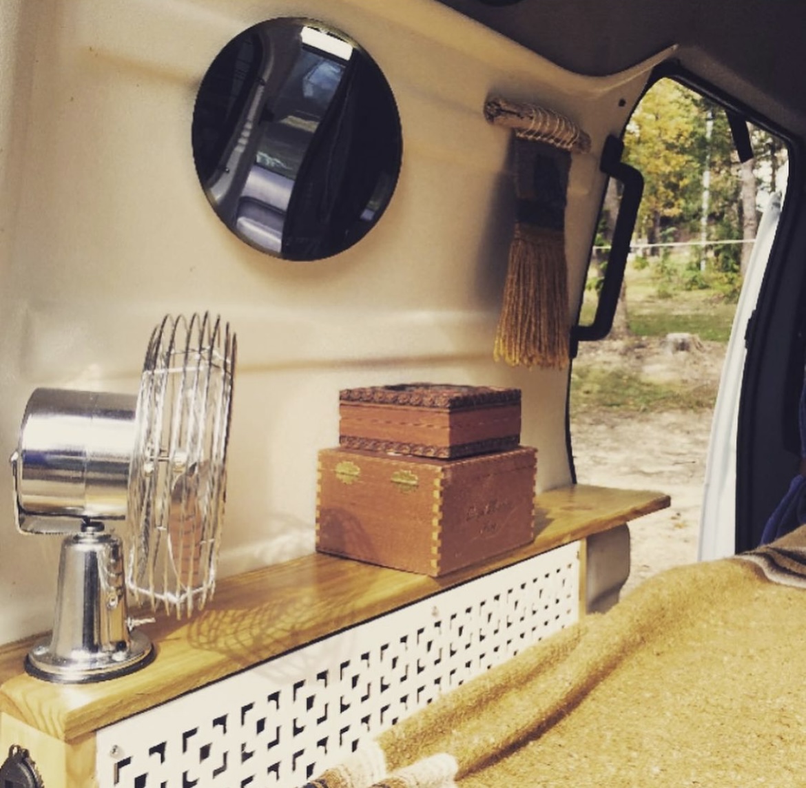 Experience our unique RV rental! This cozy van interior features a vintage fan, stacked decorative boxes, a mirror, and an. Ford Transit custom 2012