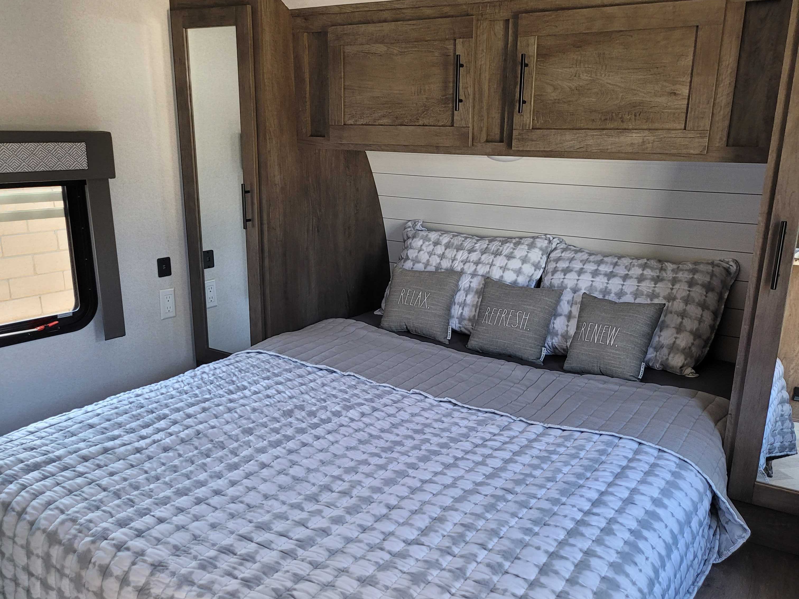 Cozy RV rental bedroom featuring a comfortable bed, modern gray decor, ample storage, and serene accents.. Forest River Salem 2021