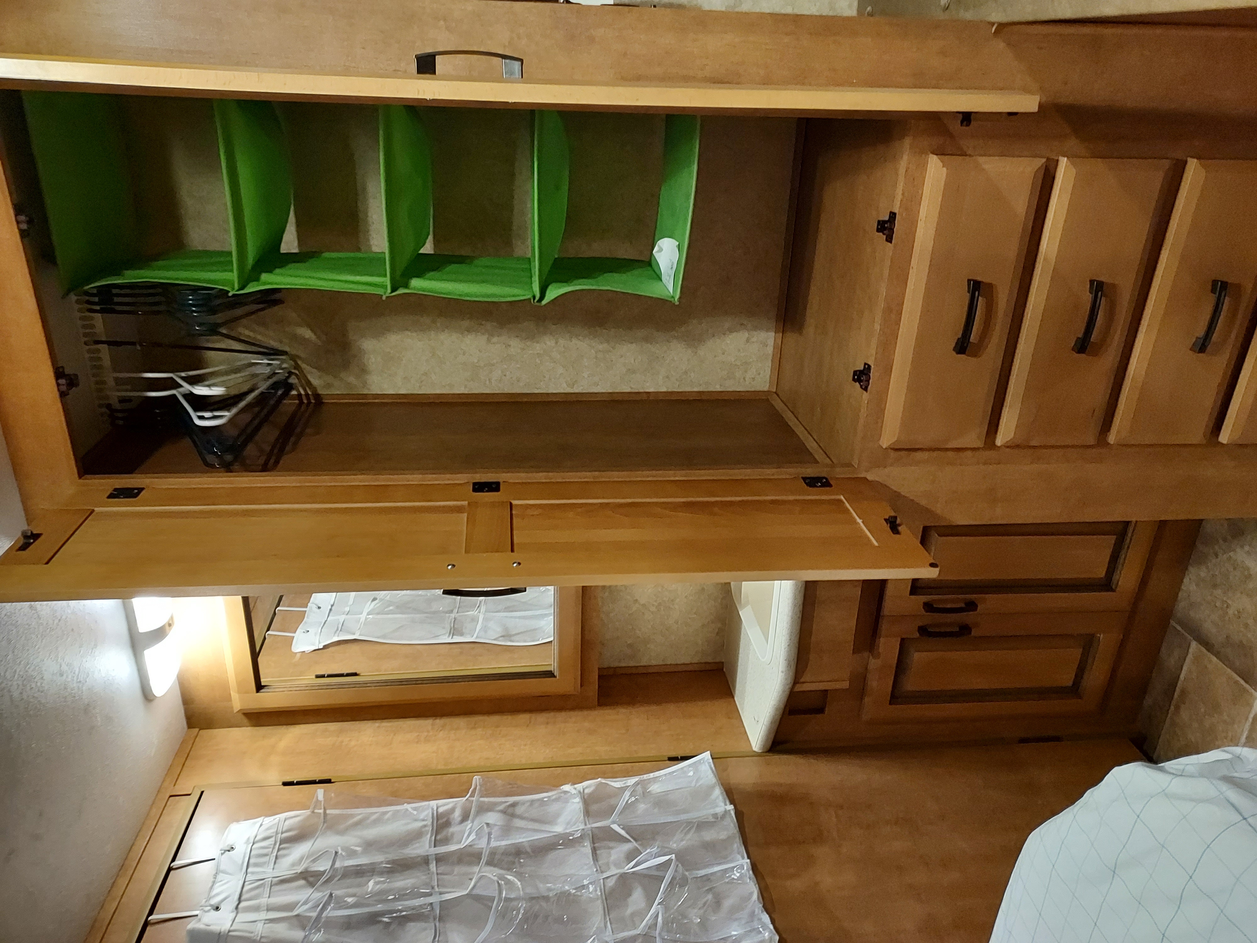 RV rental interior: storage area with open closet, green organizers, hangers, drawers, mirrored cabinet, and floor shoe organizer.. Forest River Sunseeker 2011