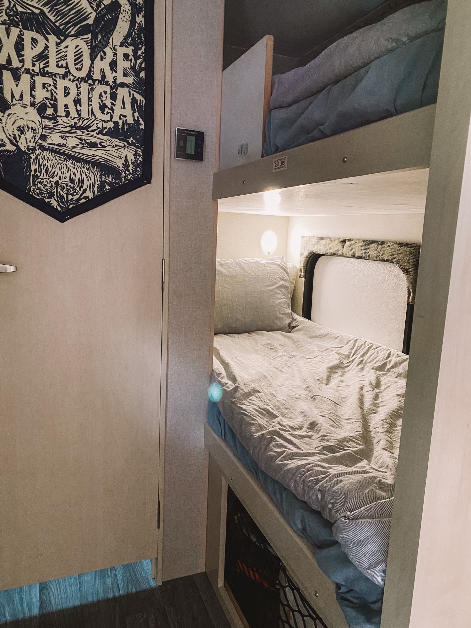 Cozy RV rental bunk beds, decorated with an "Explore America" flag, offer comfy sleeping space.. Winnebago Micro Minnie 2019