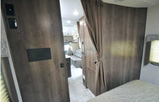 RV rental interior: View of the bedroom with privacy curtain and a glimpse into the living area with seating.. Chevrolet Other 2020