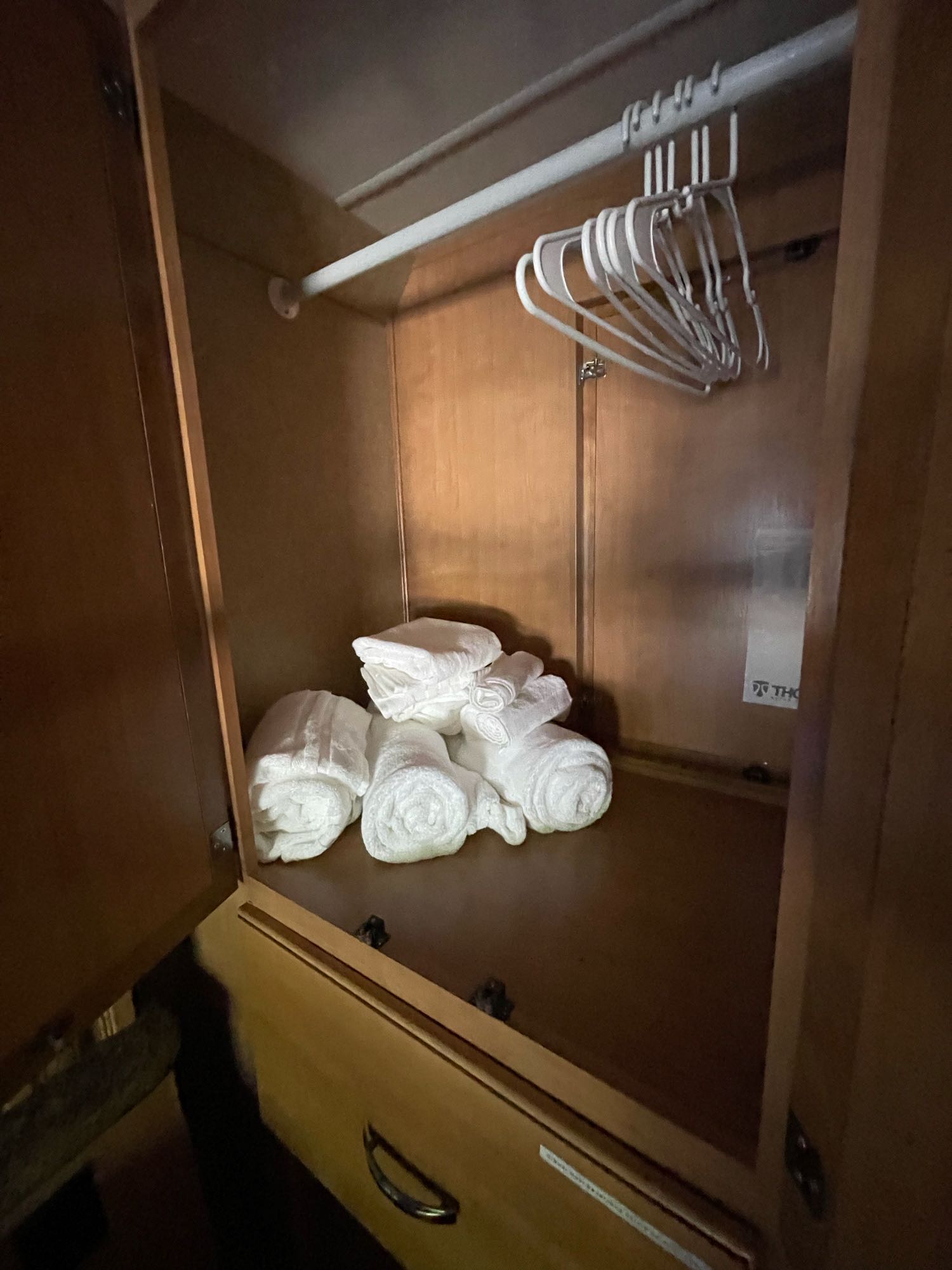 Neat storage in an RV rental: a small closet with white hangers and several clean, folded towels.. Other Freedom Elite 2017