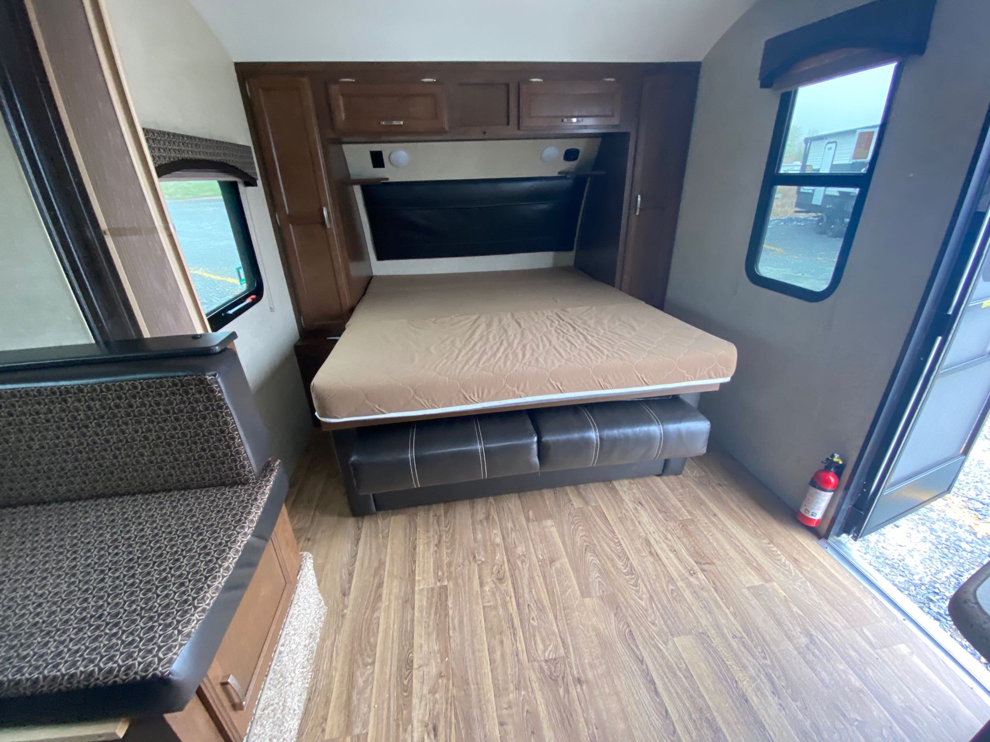 RV rental interior with comfortable bed, convertible seating, storage, and wood-look flooring.. Venture Rv Sonic 2018