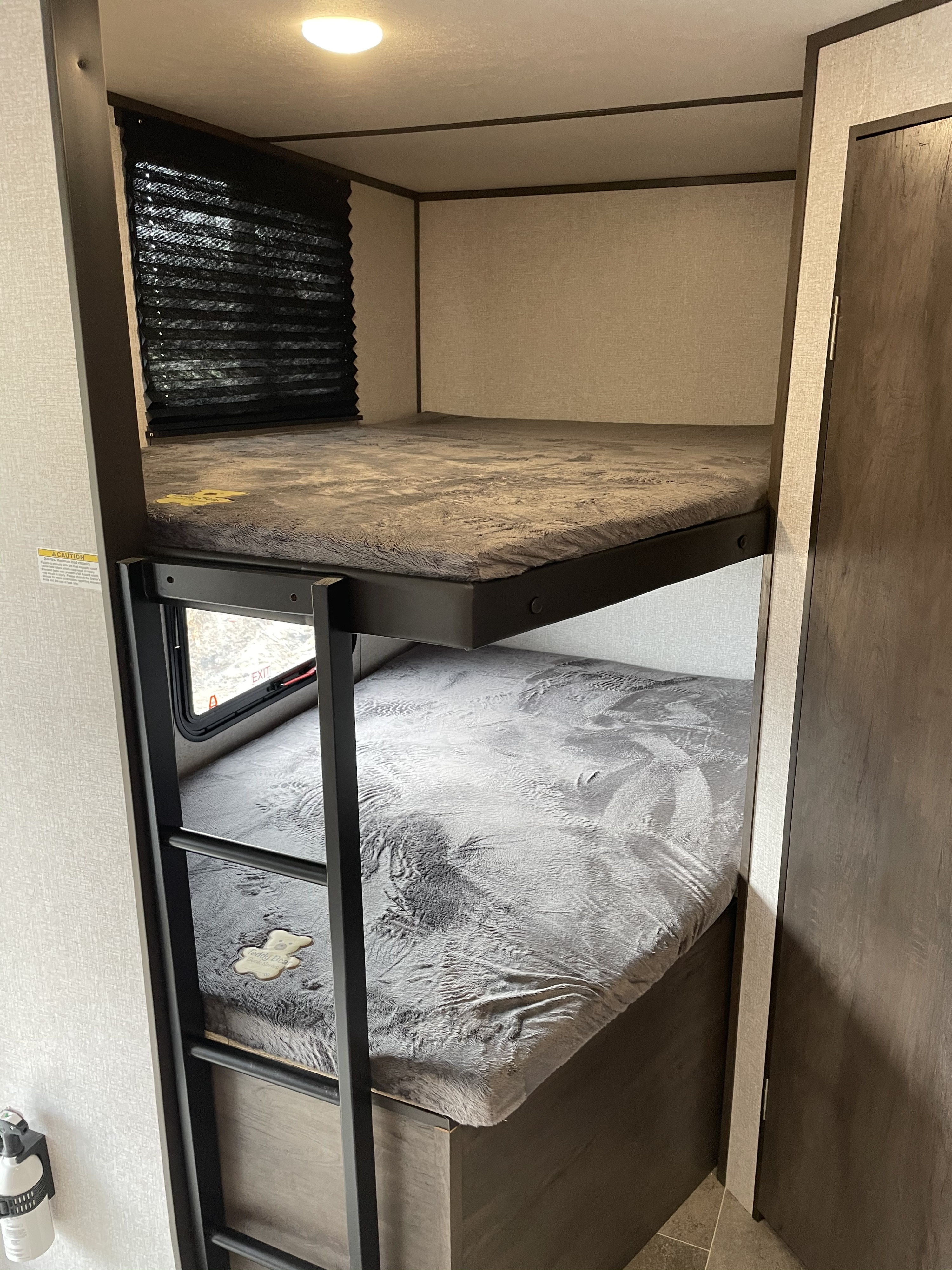 RV rental bunk bed area: two cozy bunks with soft grey bedding, windows, and a sturdy ladder for easy access.. Dutchmen Coleman 2021