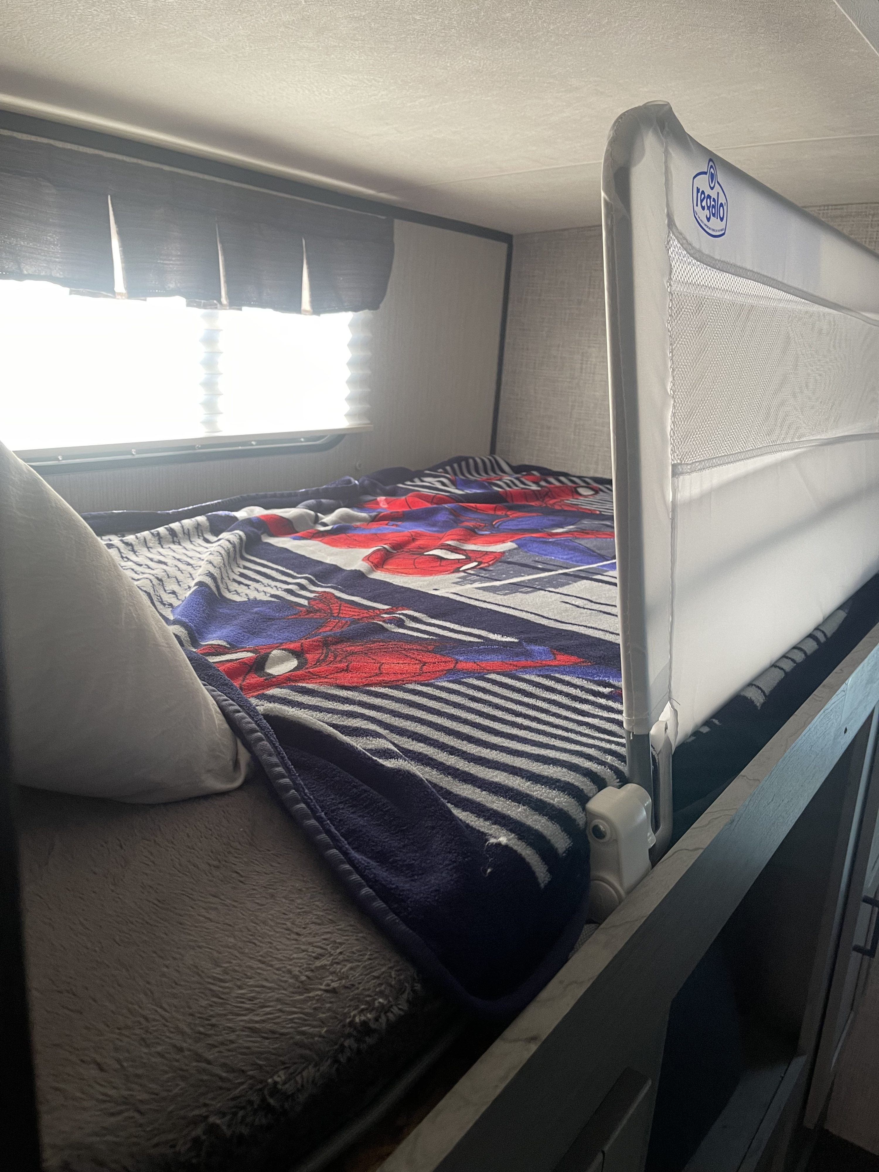 Cozy RV rental bunk bed with Spider-Man blanket and a Regalo safety rail, ideal for secure sleeping on the go.. Heartland Mallard 2020