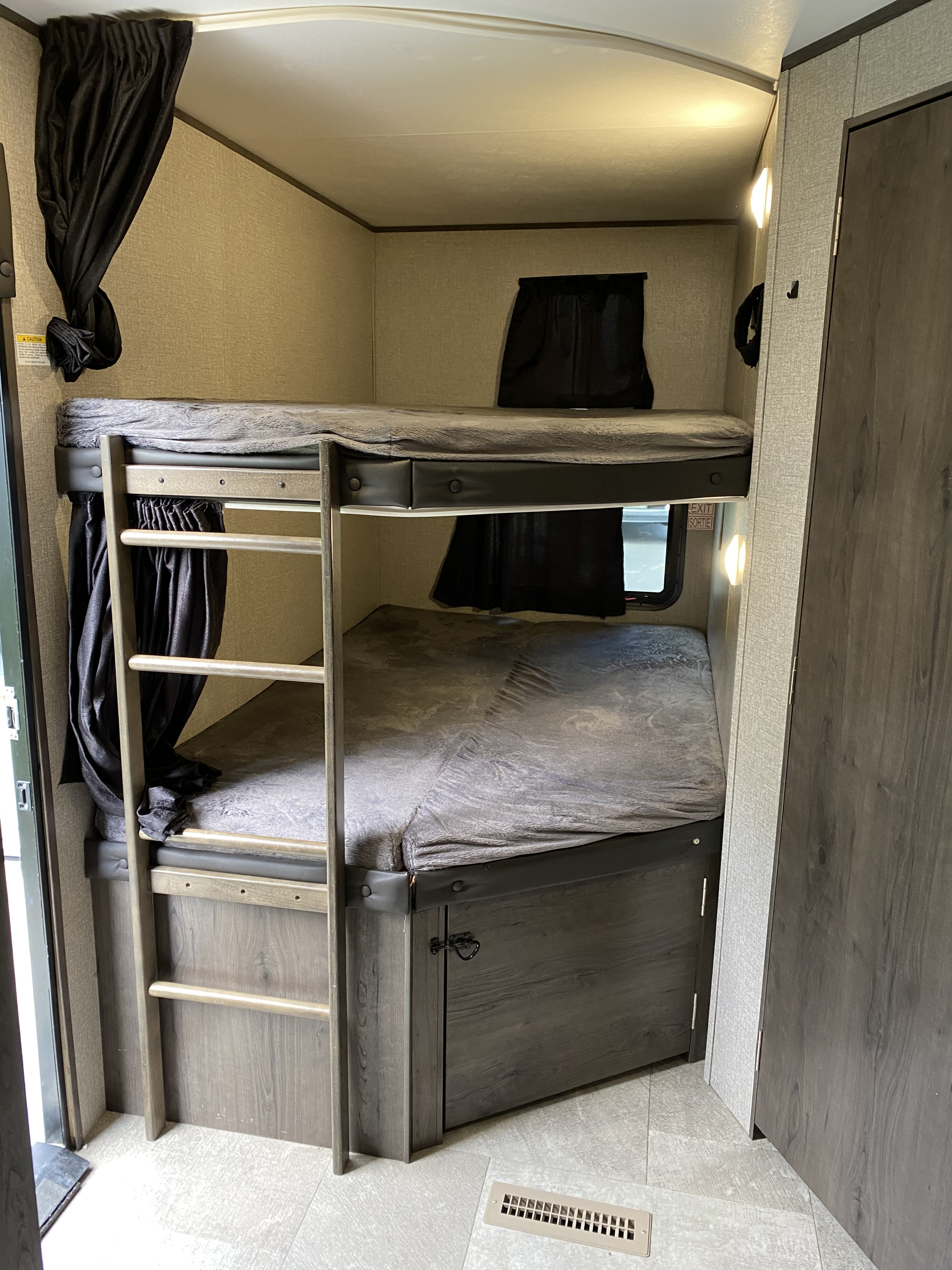 RV rental bunk beds feature cozy gray bedding, privacy curtains, and a ladder, perfect for group or family adventures.. Jayco Jay Flight 2020