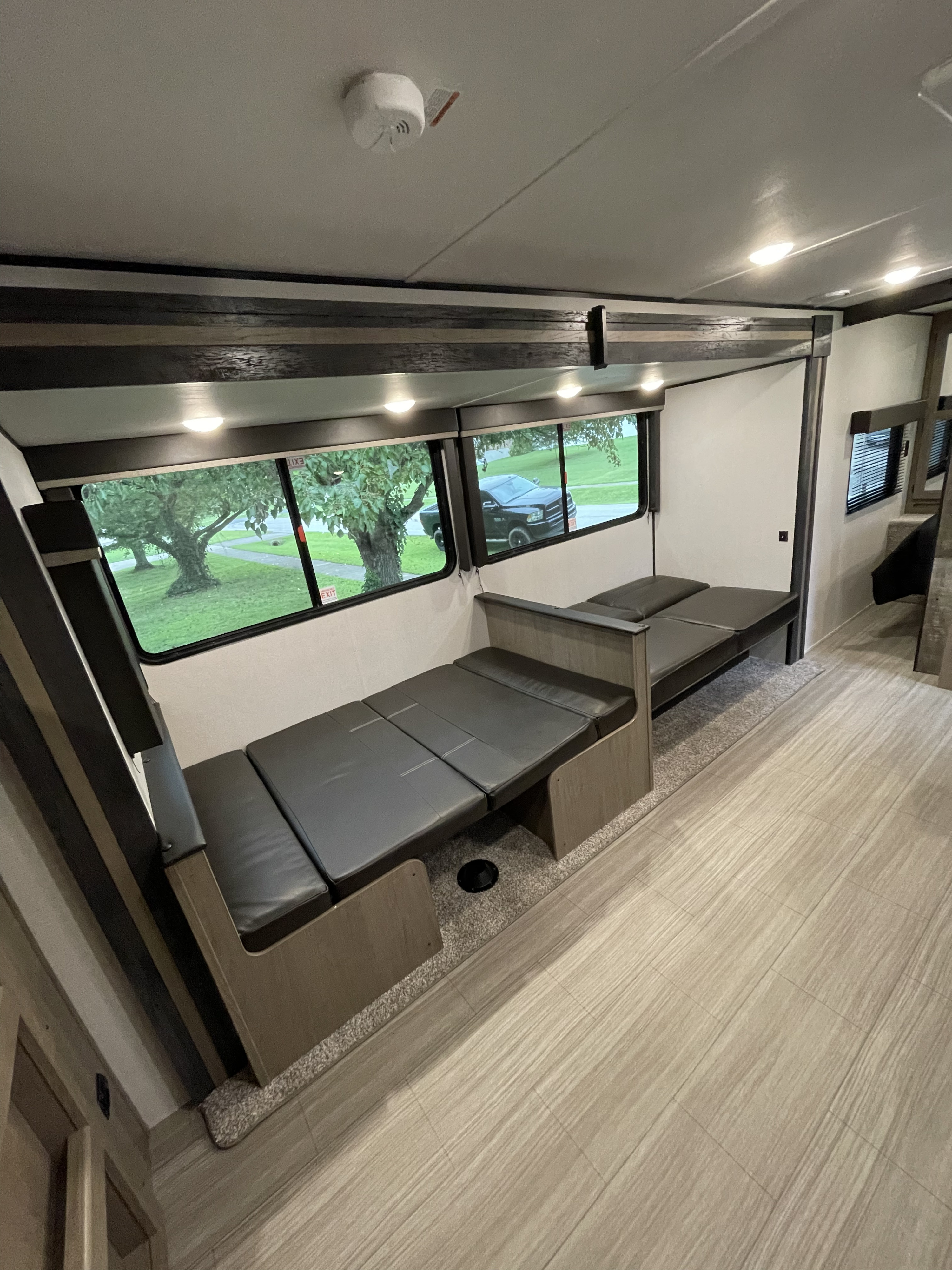 RV rental: Clean, well-lit interior with dark-cushioned benches that make into beds, ample windows, and light wood flooring.. Keystone Hideout 2021