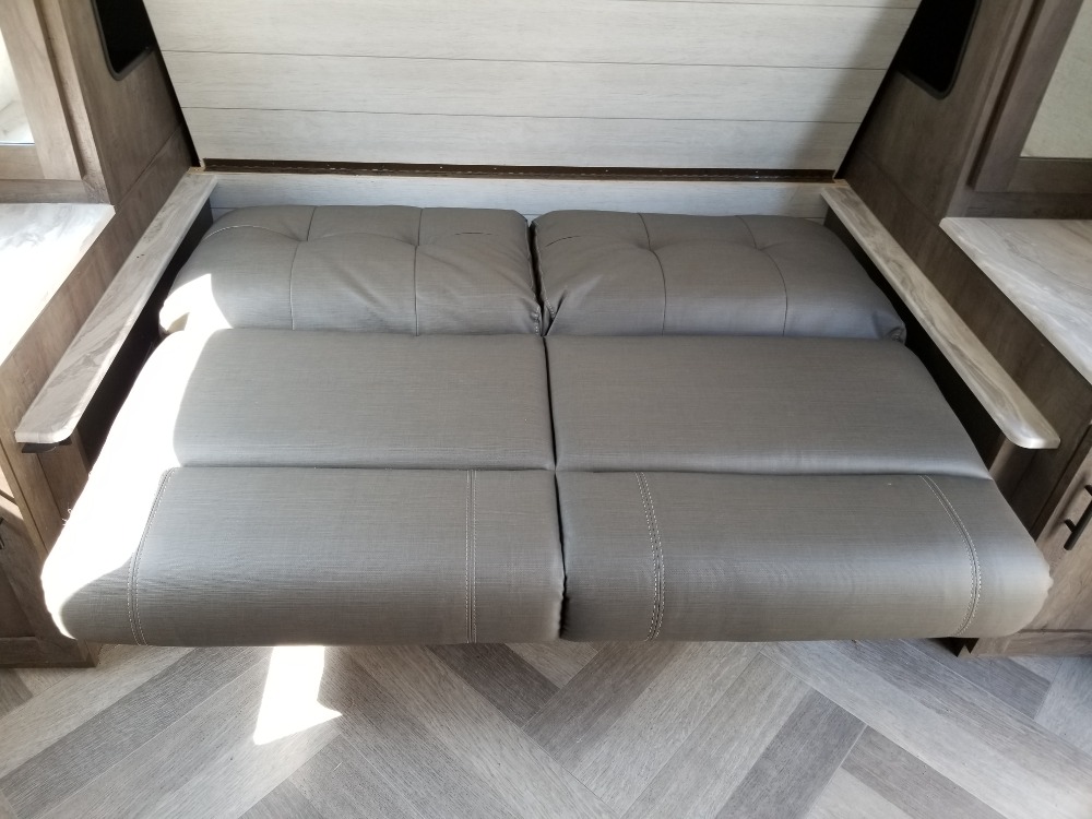 Modern gray modular seating in an RV rental, likely converting to a bed. Ideal for compact camper interiors.. Forest River Salem Cruise Lite 2021