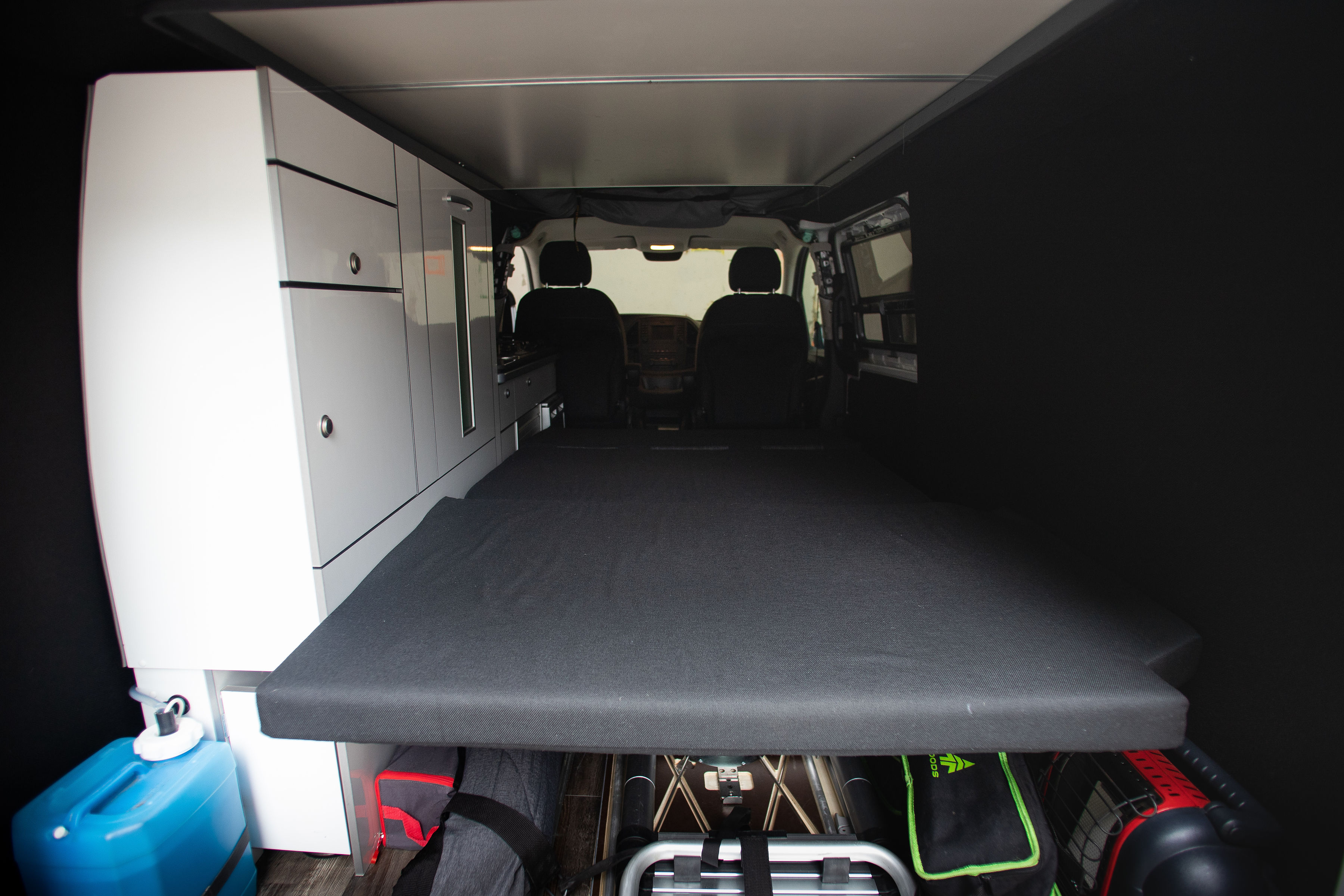 Spacious rv rental campervan interior features a comfy bed, sleek white cabinets, and clever under-bed storage.. Mercedes-Benz Metris 2016