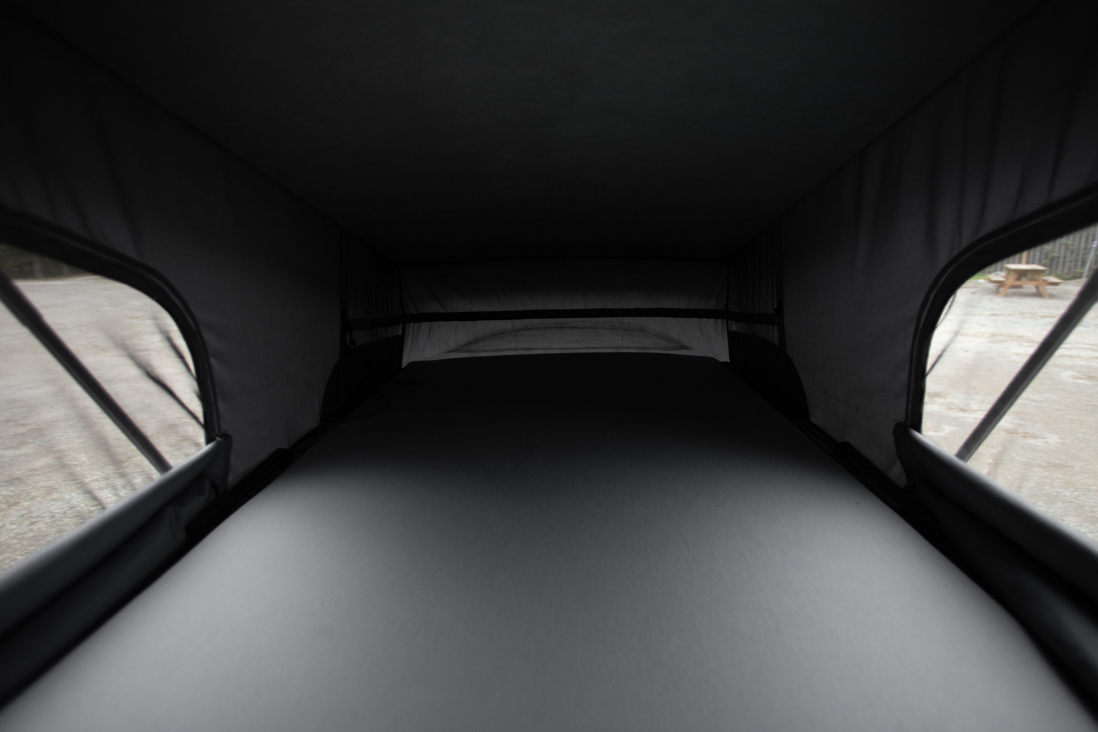 RV rental pop-top interior: A dark, comfortable sleeping space with large side windows offering outdoor views.. Mercedes-Benz Metris 2016