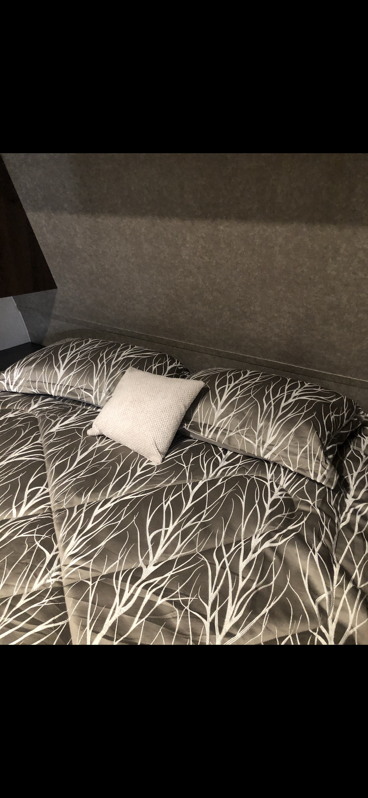 RV rental interior: Comfortable bed with grey & white tree-branch pattern bedding & light pillow.. Jayco Flight 2019