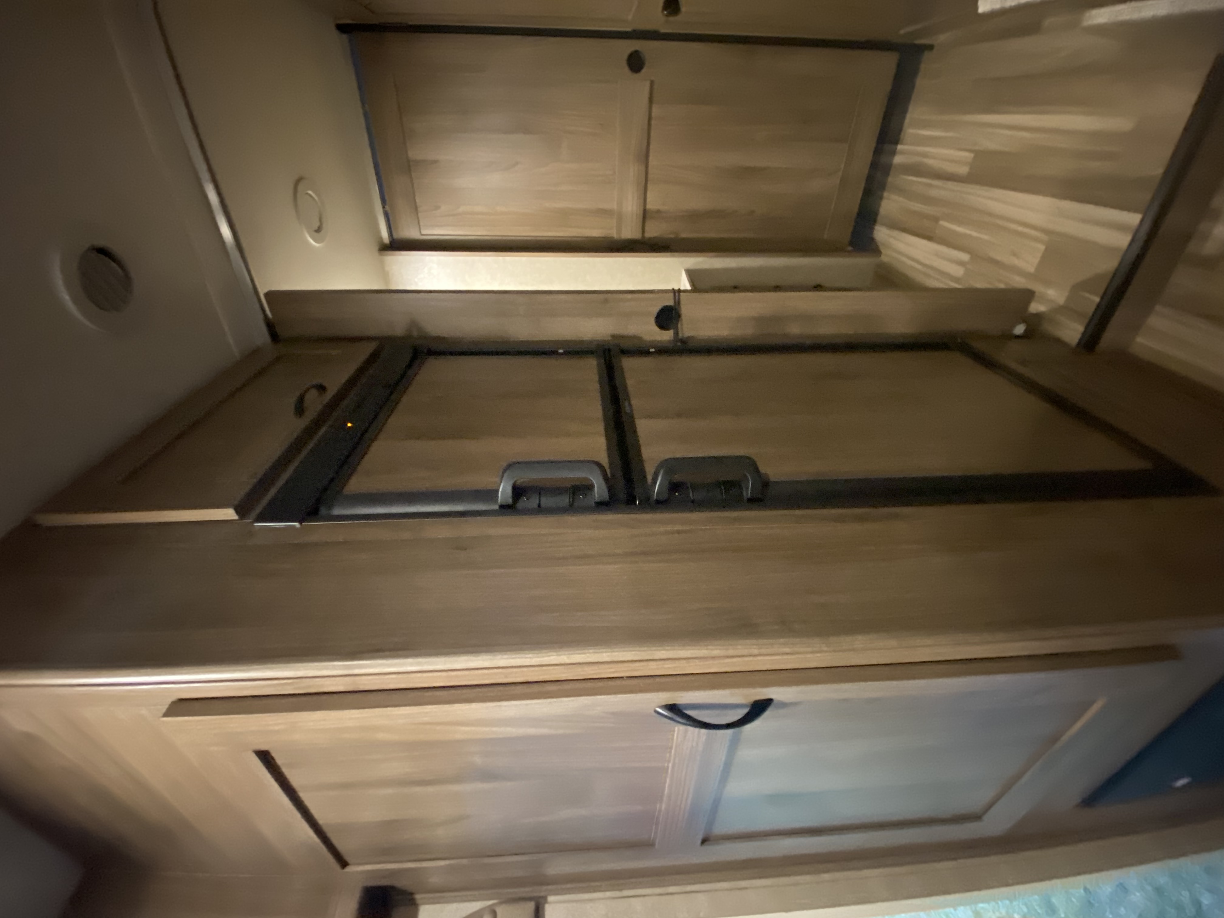 RV rental interior: Overhead cabinets, vent, and kitchen counter covers with handles. Compact and functional space.. Coachmen Freelander 2016