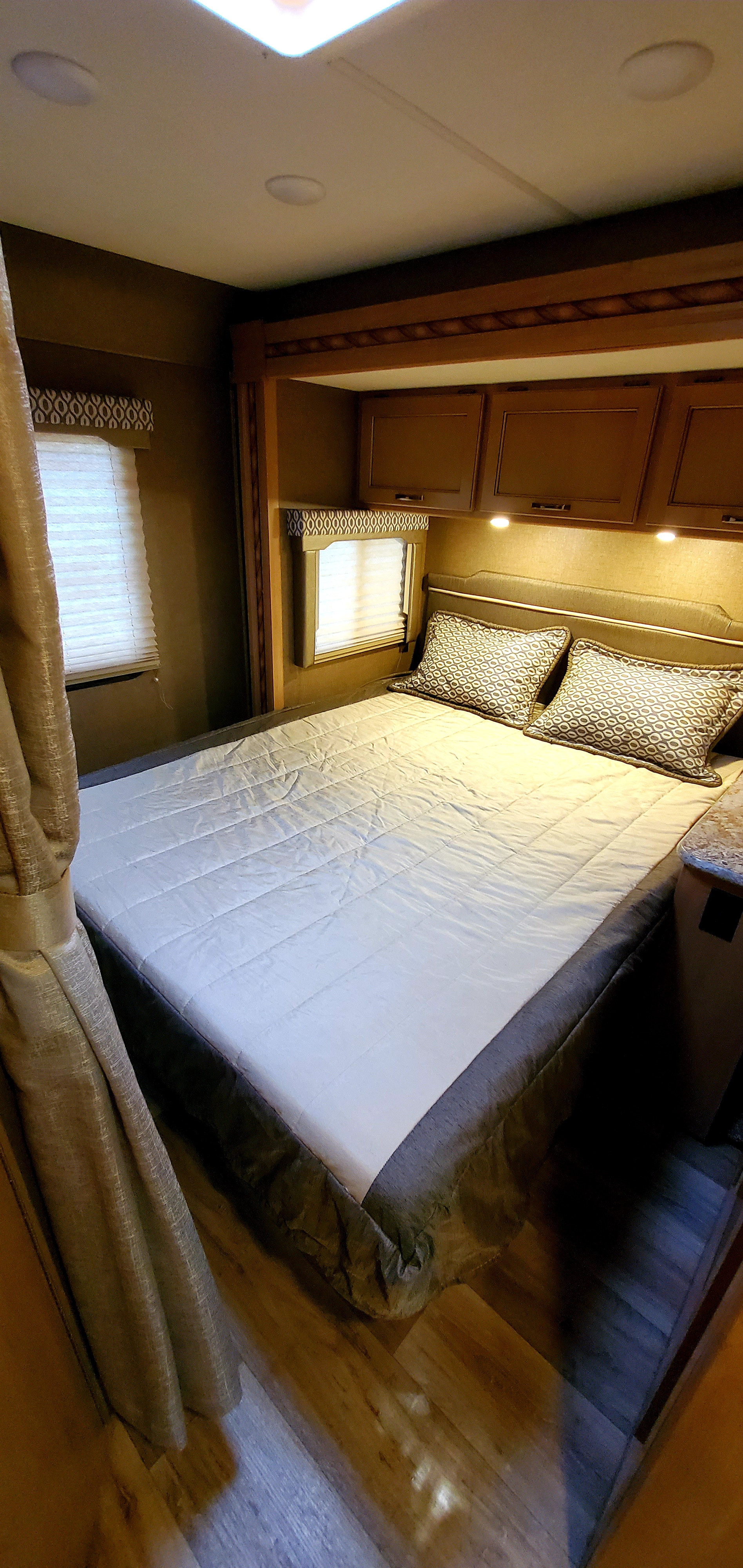 RV rental bedroom: a neat, compact space with a comfortable bed, overhead cabinets, and bright windows.. Other Other 2018