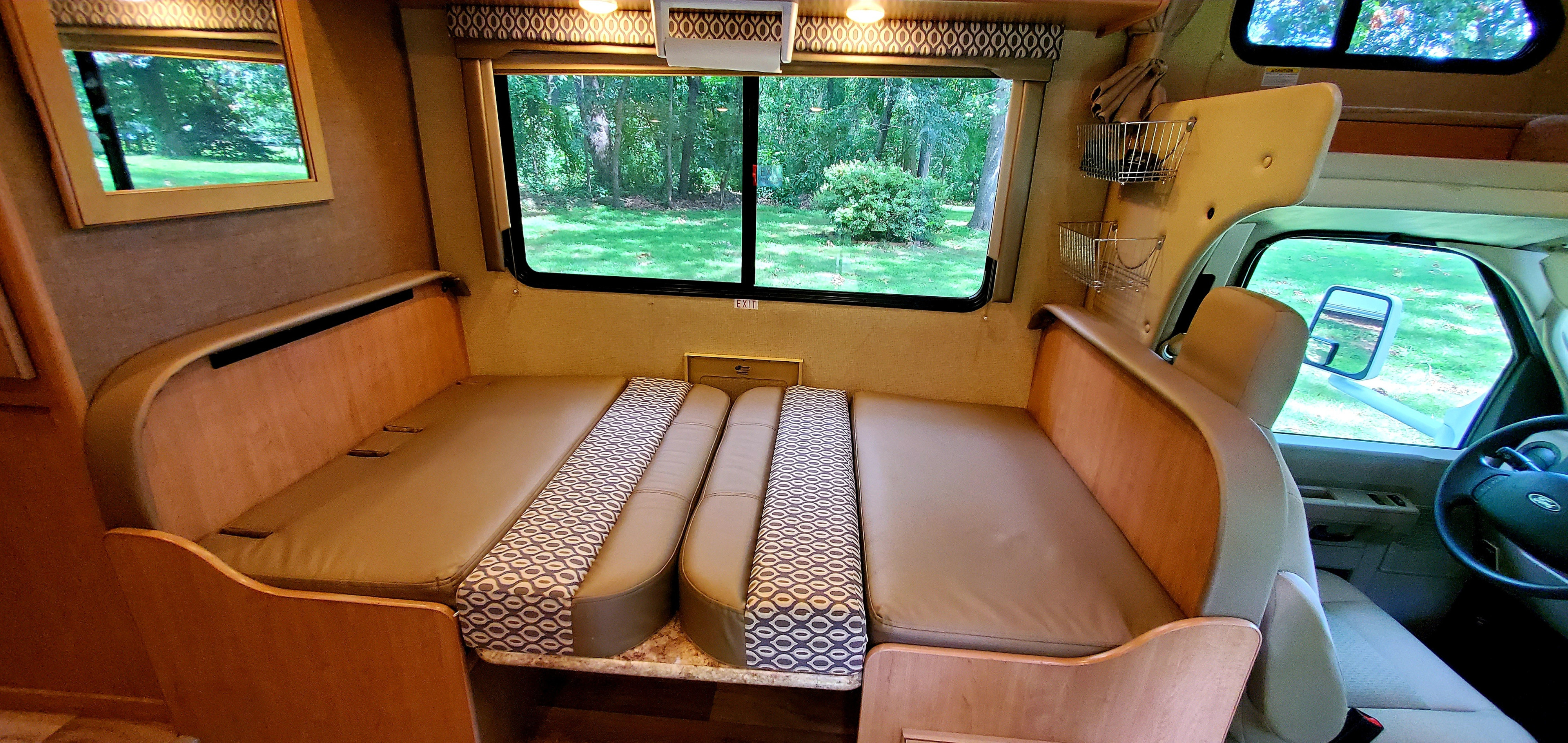 RV rental interior with a versatile dinette providing seating/sleeping and scenic green views.. Other Other 2018