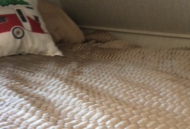 Cozy RV rental bed, a quilted tan comforter with a camper pillow. Perfect for road trips and adventure!. Jayco Redhawk 2018