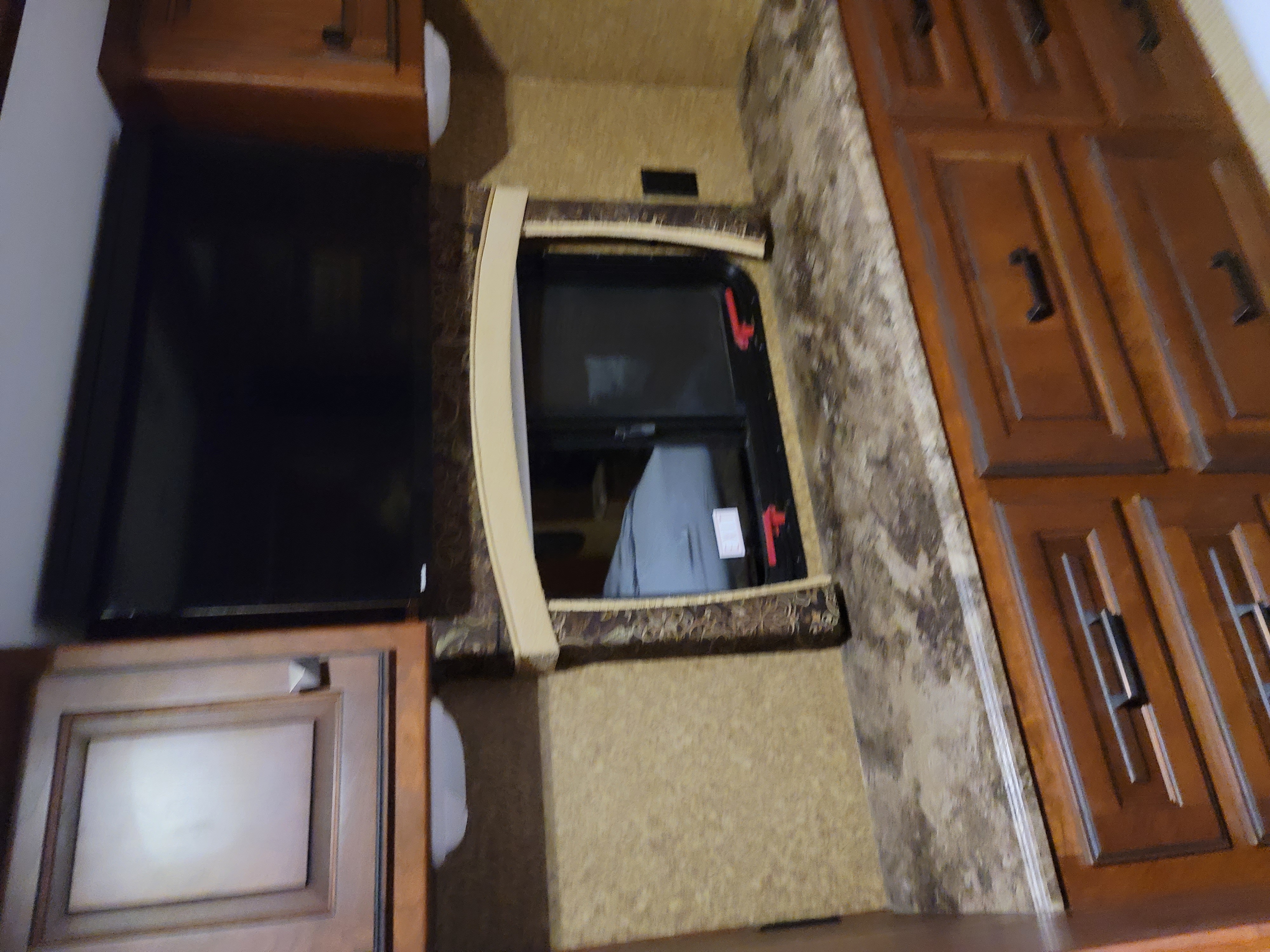 RV rental interior: wall-mounted TV, window with red latches, adjacent wood cabinets, and cushioned seating.. Forest River Other 2014