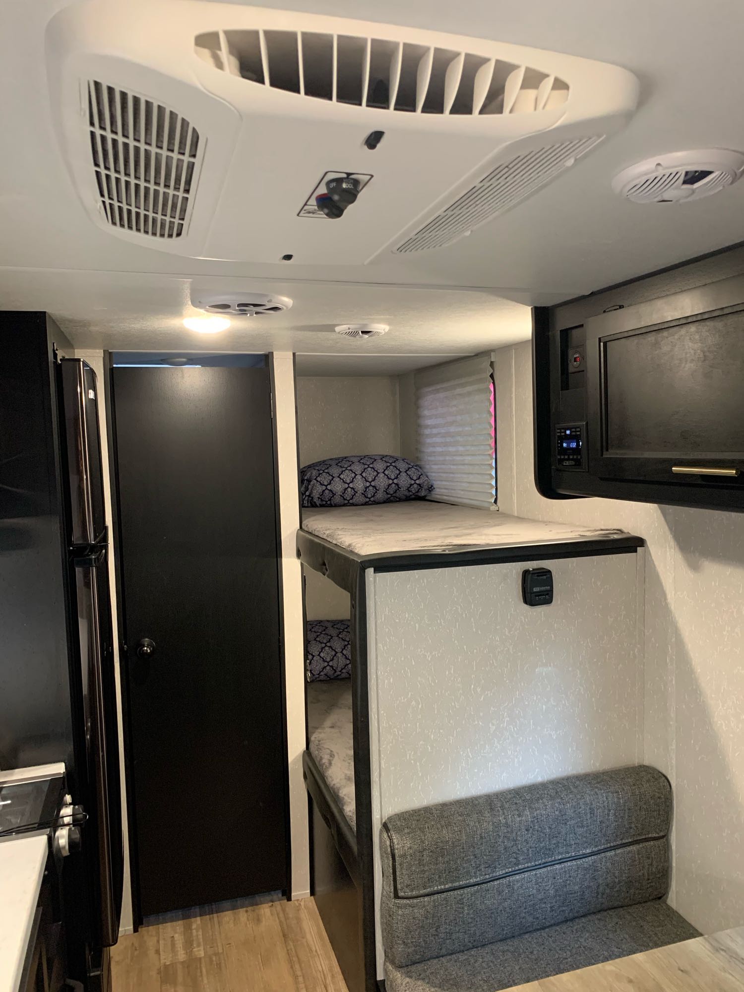 Modern RV rental interior with comfortable bunk beds, compact kitchen, dinette, and climate control.. Forest River Cherokee Wolf Pup 2021