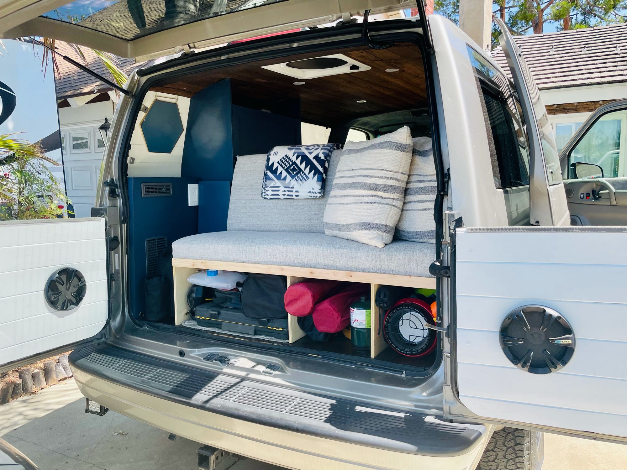 View of a cozy camper van interior with custom bench, wood ceiling & storage, ready for rv rental adventures.. Chevrolet Astro Van AWD 2003