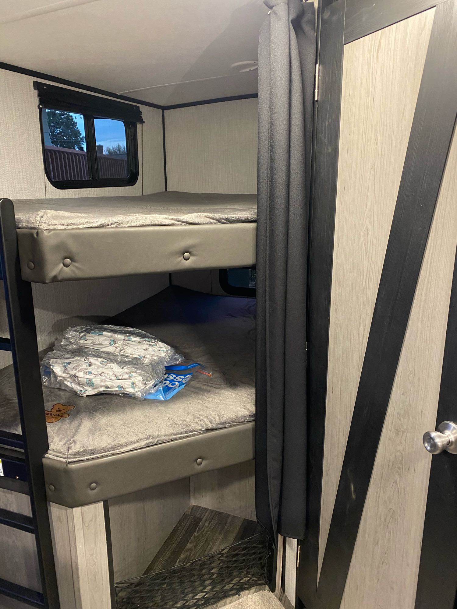 RV rental bunk beds, with a window, privacy curtain, and modern barn door. Perfect for family travel.. Heartland Mallard 2021