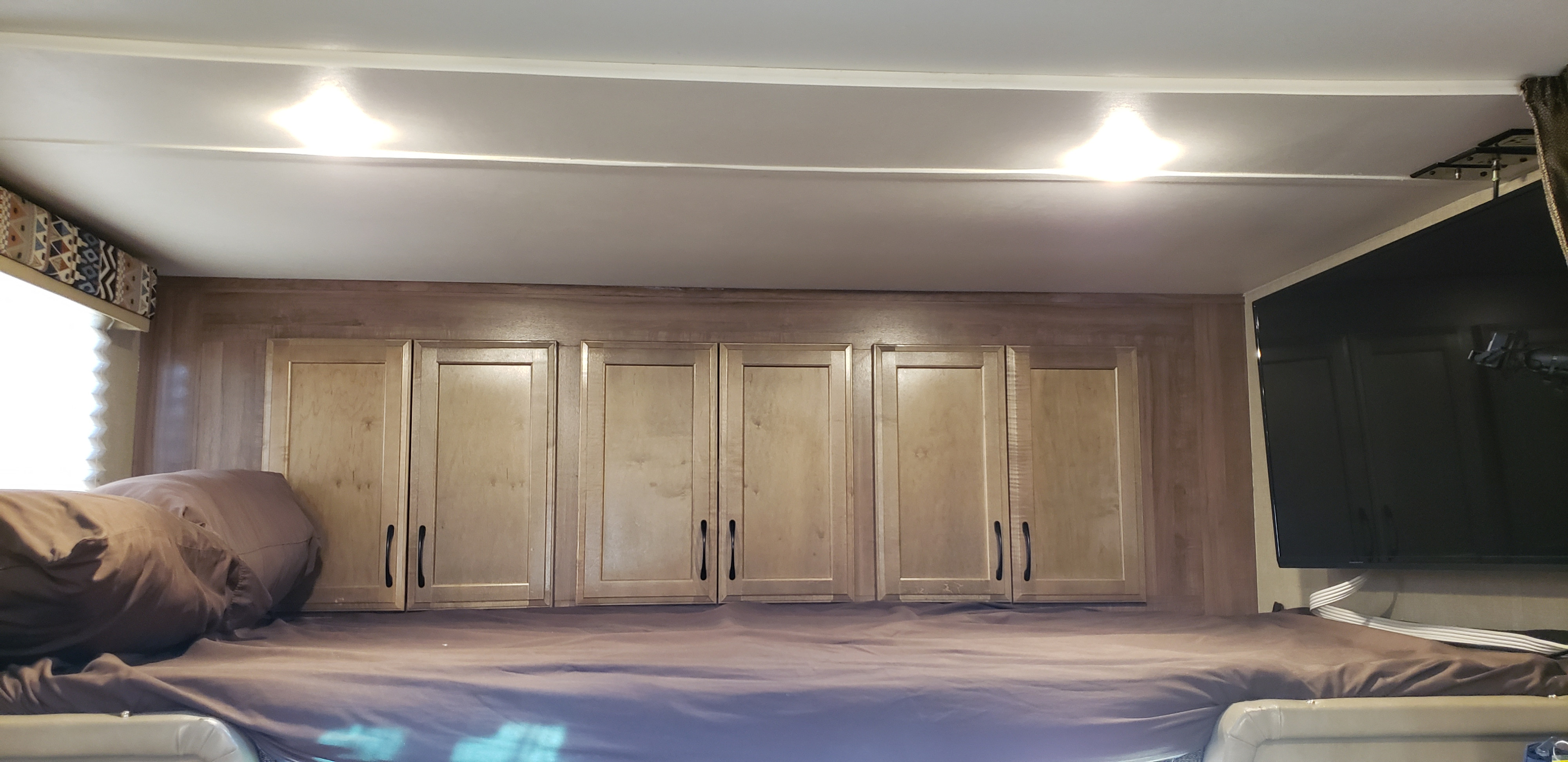 RV rental interior: comfortable bunk bed, wood cabinets, TV, and window for a cozy stay.. Gulf Stream Conquest 2018