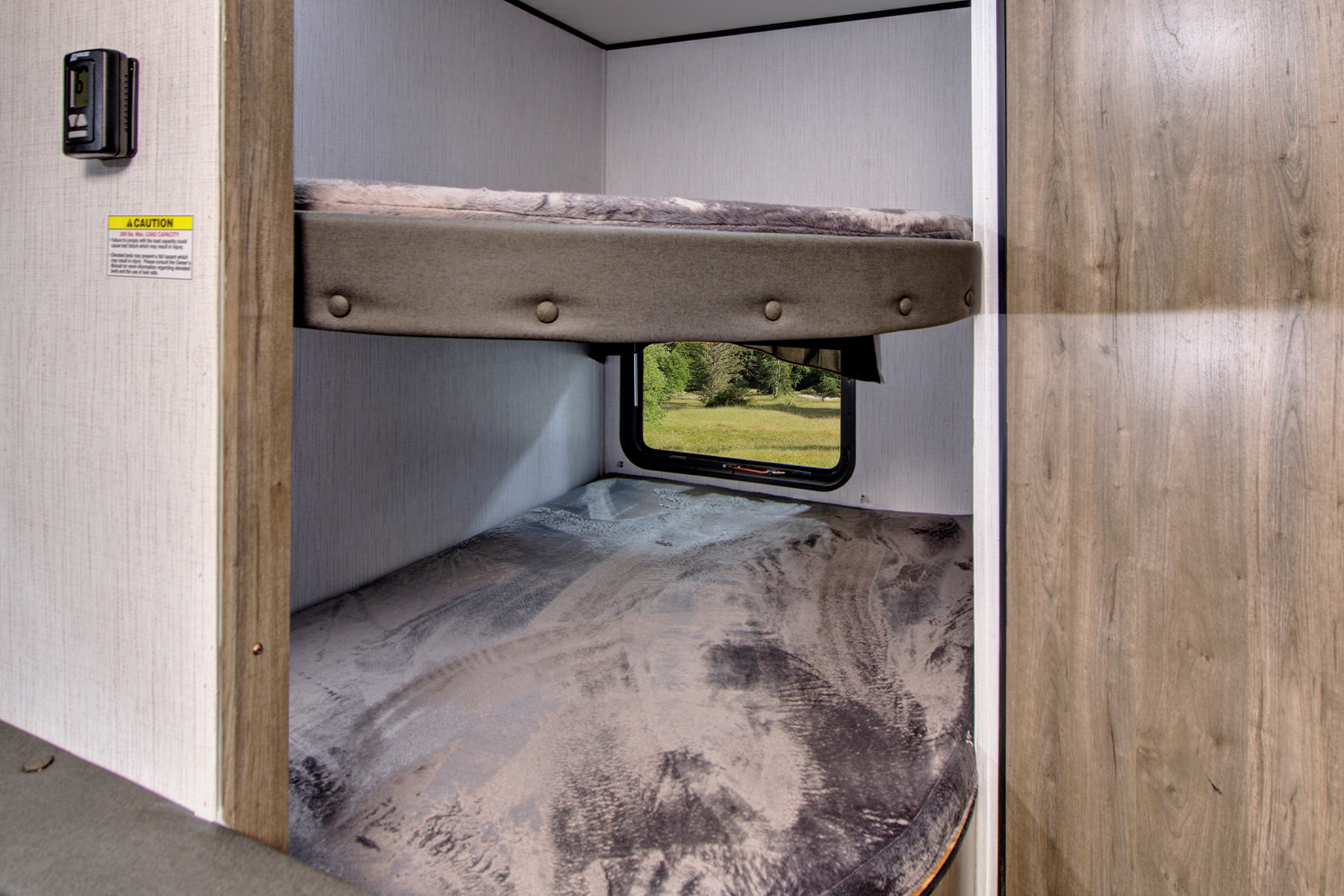 Cozy bunk beds inside an RV rental, featuring a window view for comfortable camping and travel adventures.. Heartland Pioneer 2021