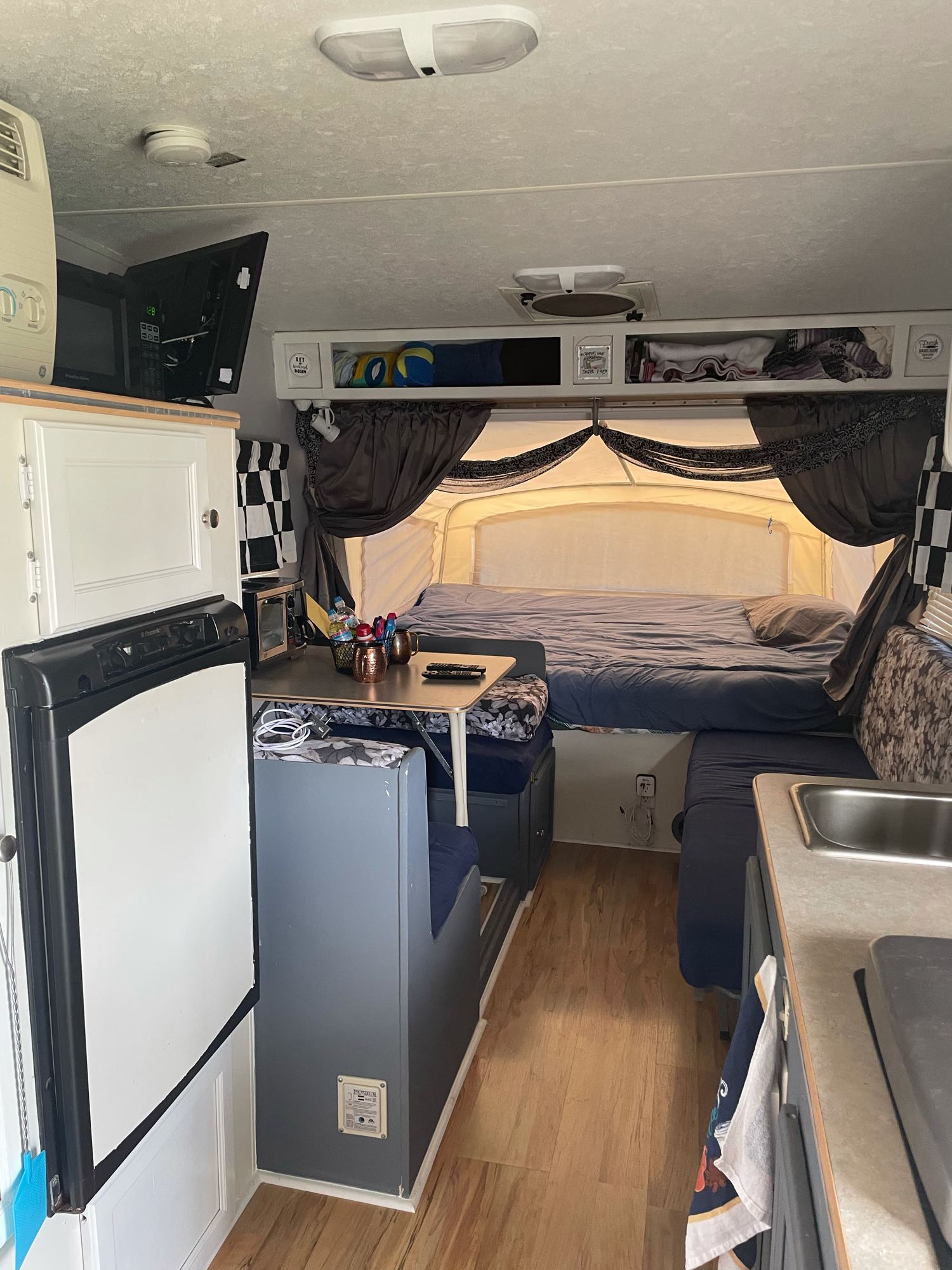 RV rental interior showing a large pop-up bed, dining area, kitchen, and fridge. Ready for your next travel adventure!. R-Vision Bantam 17 2004