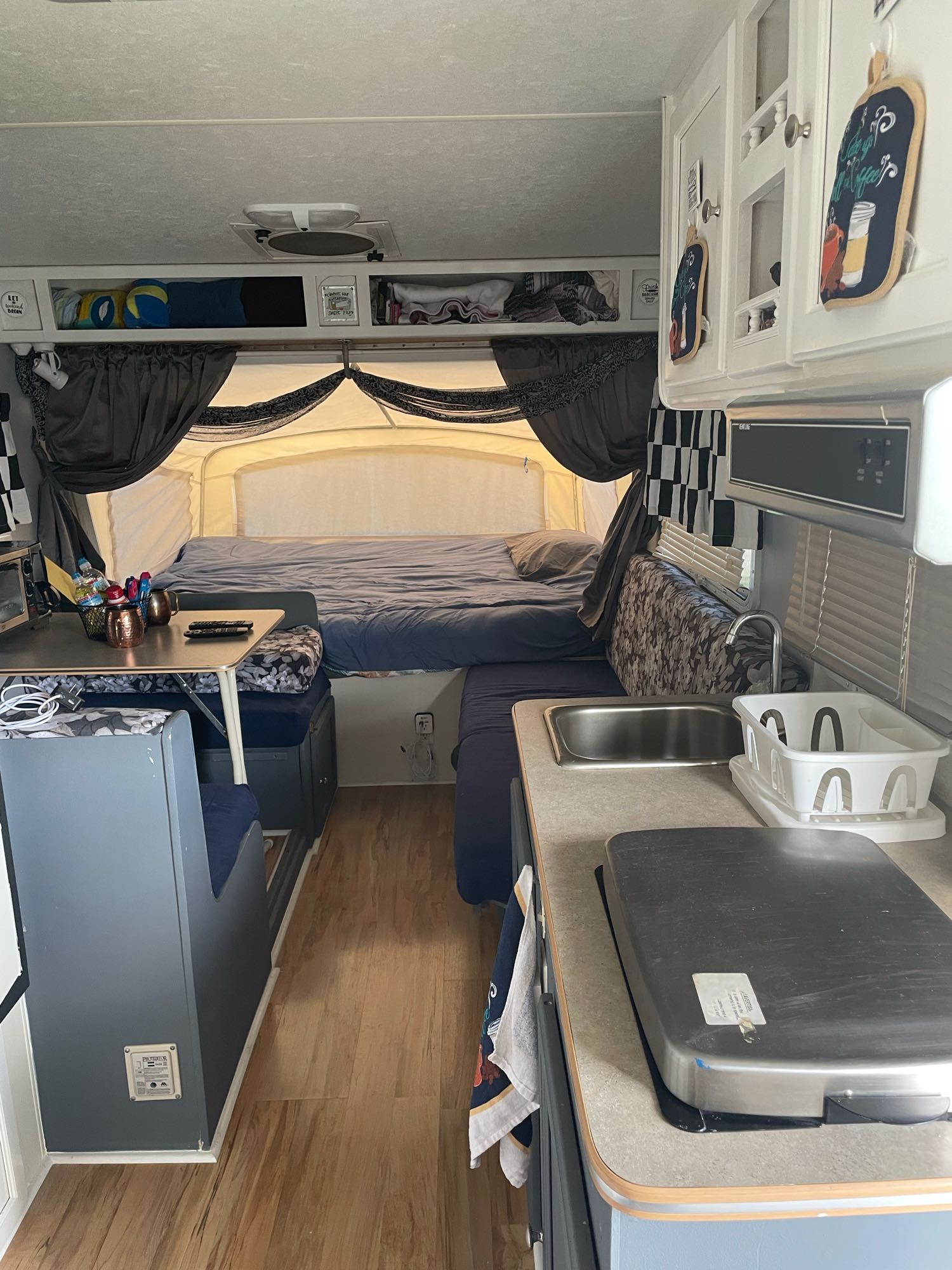 Inside an rv rental: a pop-up camper's compact living space with bed, kitchen, and dining for travel.. R-Vision Bantam 17 2004