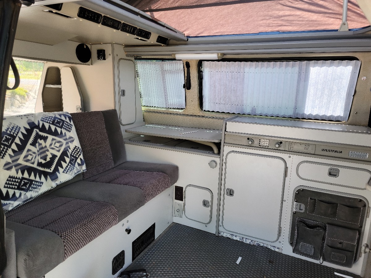Cozy Westfalia camper van interior: living area, kitchen, and bed setup, perfect for your next rv rental adventure.. Volkswagen Vanagon 1990