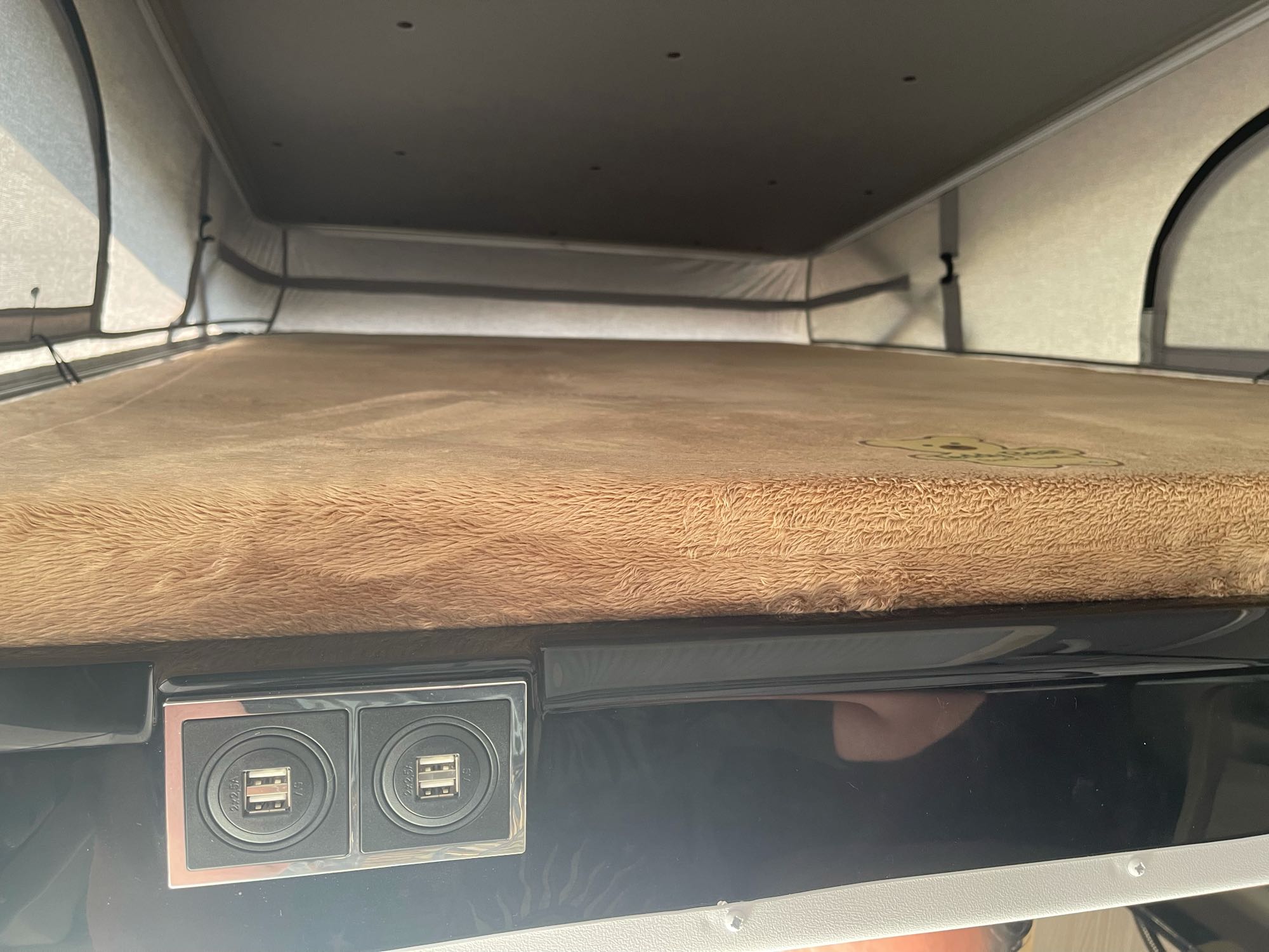 RV rental pop-top camper interior with a cozy bed and dual USB charging ports. Ideal sleeping space for your next adventure.. Thor Sequence 2022