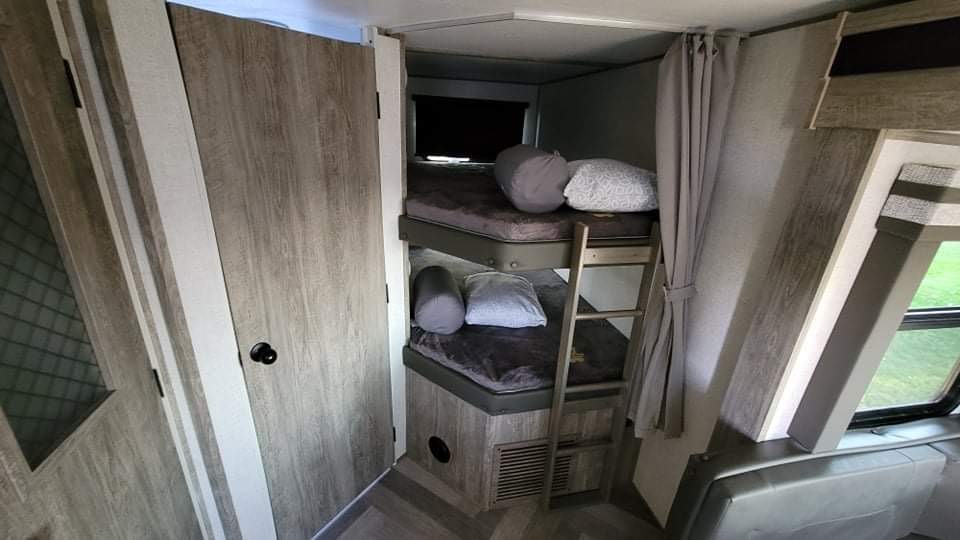 RV rental interior: cozy bunk beds with ladder, pillows, and window views for comfortable sleeping in your camper.. Forest River Salem Hemisphere 2021