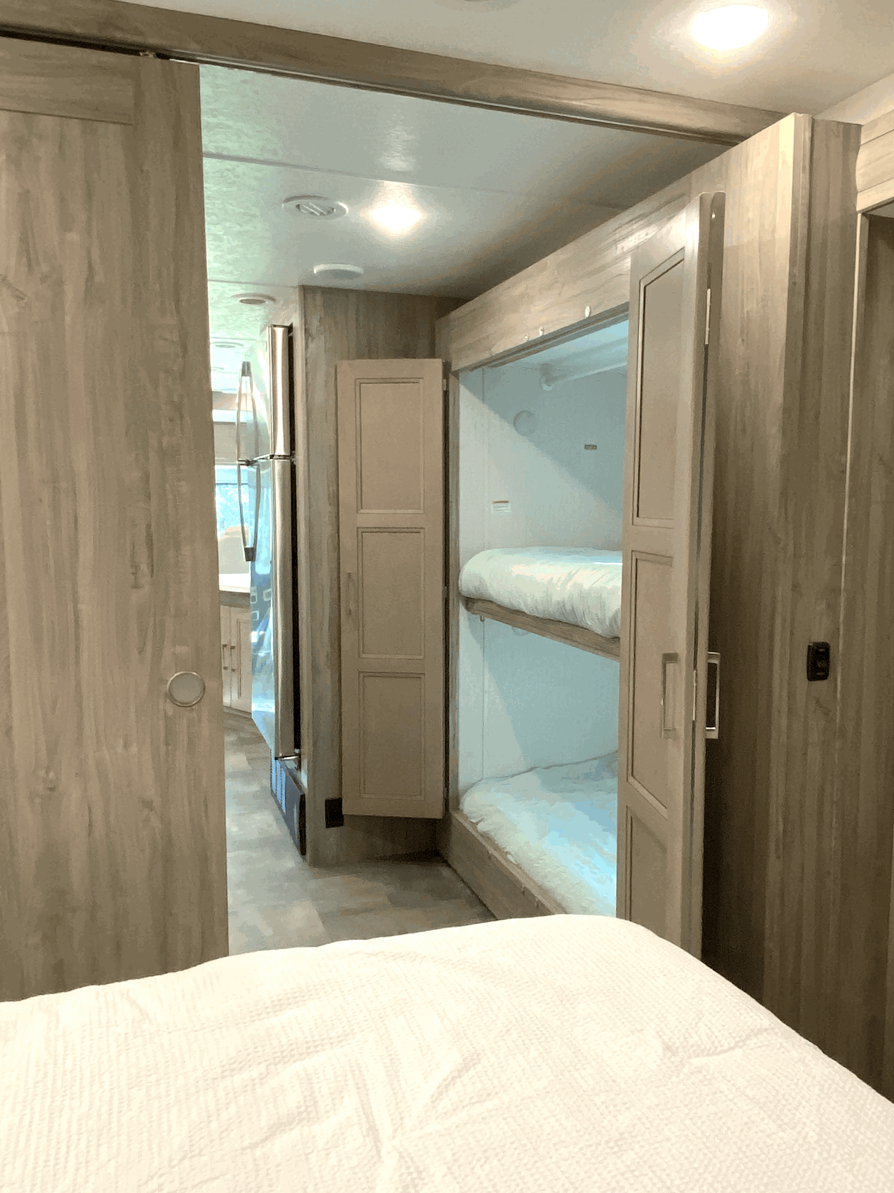 RV rental showing a master bed, sliding door leading to kitchen area, and built-in bunk beds.. Coachmen Mirada 2021
