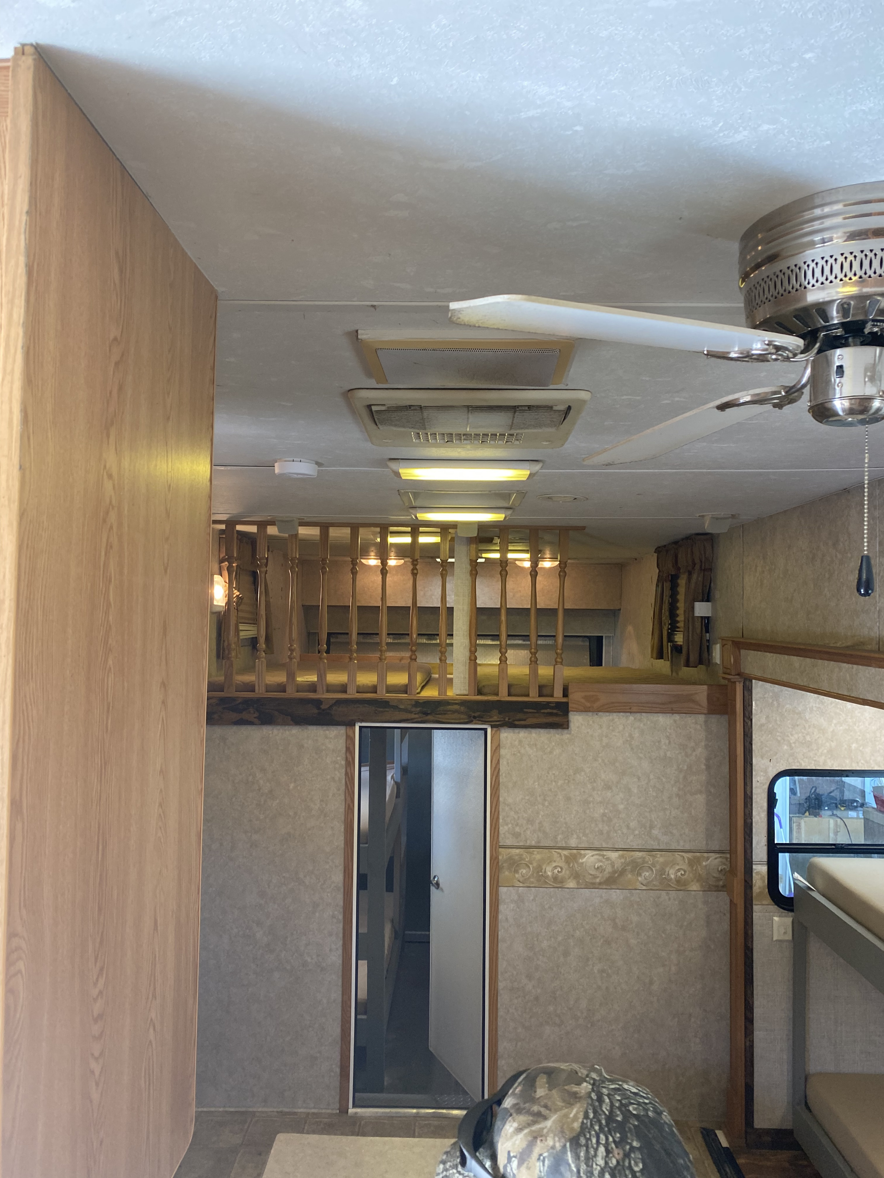Spacious RV rental interior featuring a cozy sleeping loft, bunk beds, ceiling fan, and ample overhead lighting.. Sunnybrook Mobile Scout 2007