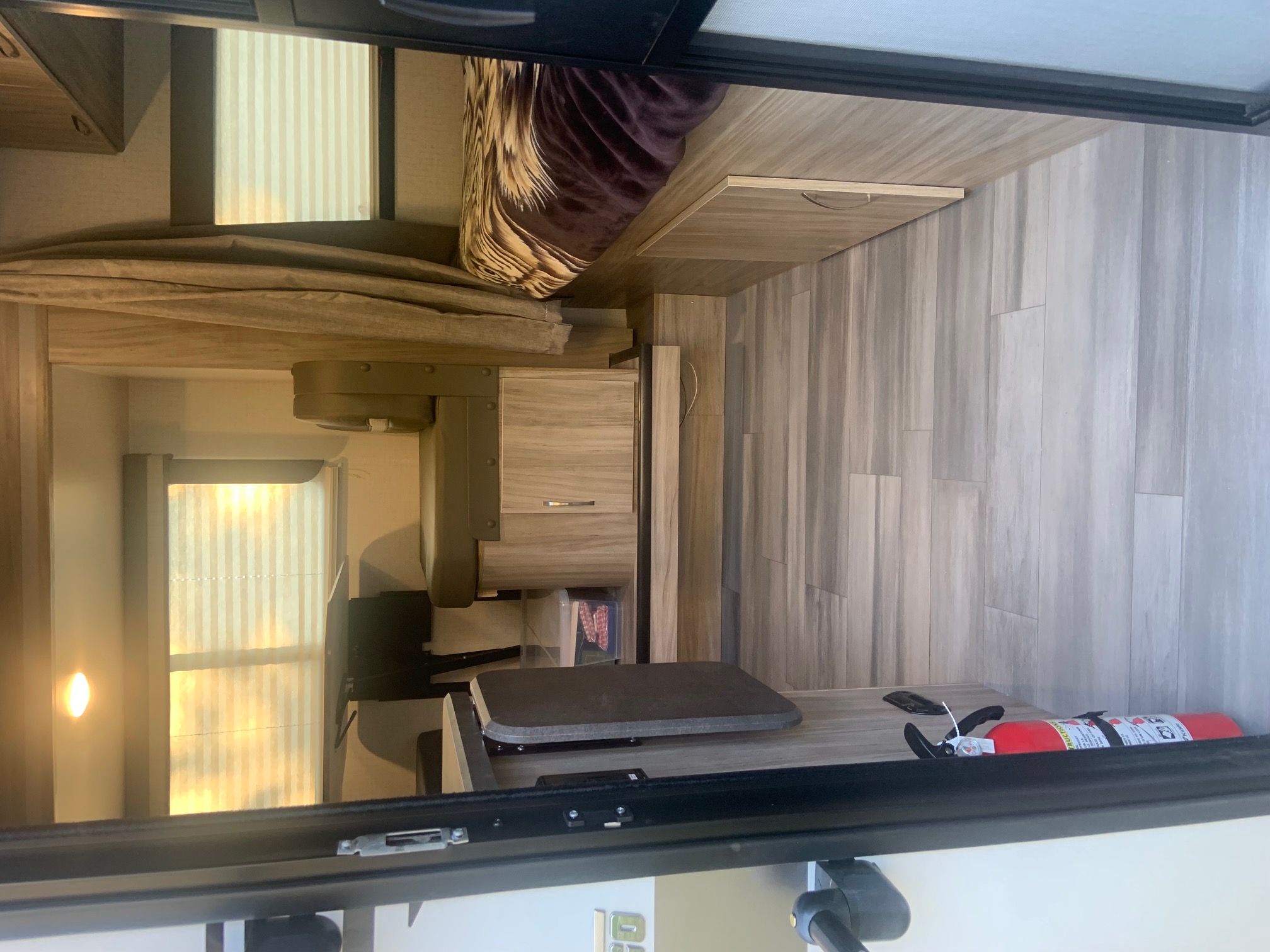 RV rental interior featuring a compact living space, complete with bed, dining area, and storage.. Winnebago Micro Minnie 2021