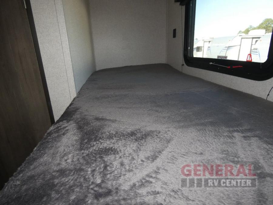 Cozy RV rental bunk bed interior with a plush gray mattress and window view of outdoor RVs. Ideal sleeping area.. Coachmen Clipper 2022