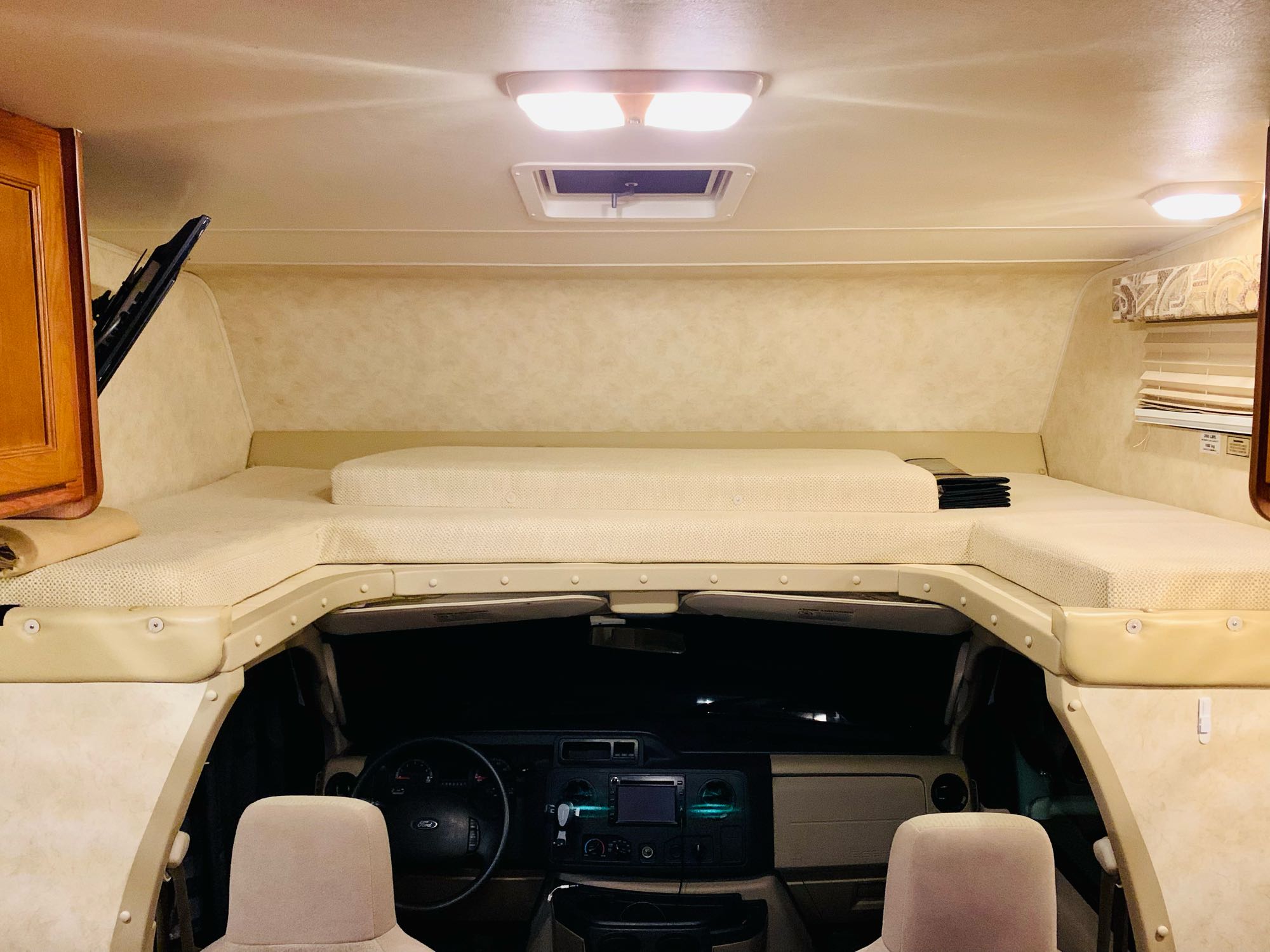 Experience an RV rental! Interior view of the comfortable cab-over bunk and dashboard below.. Coachman Ford E350 2013