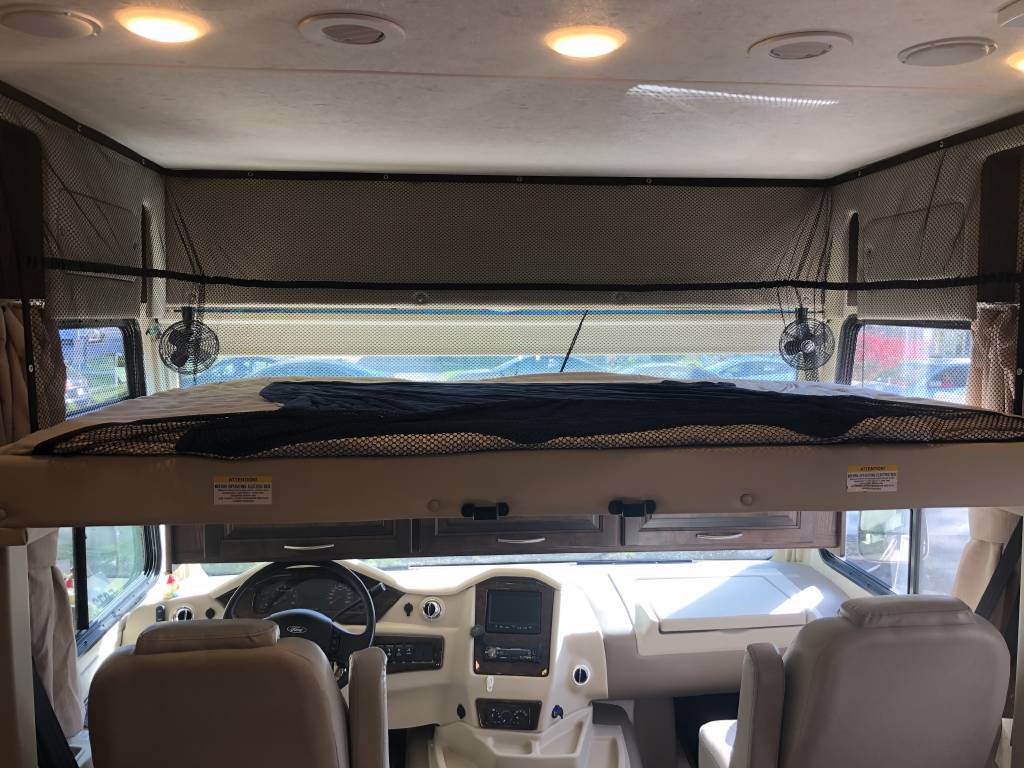 RV rental interior: over-cab bunk bed with safety net & fans, looking into the cockpit.. Coachmen Mirada A-Class 2019