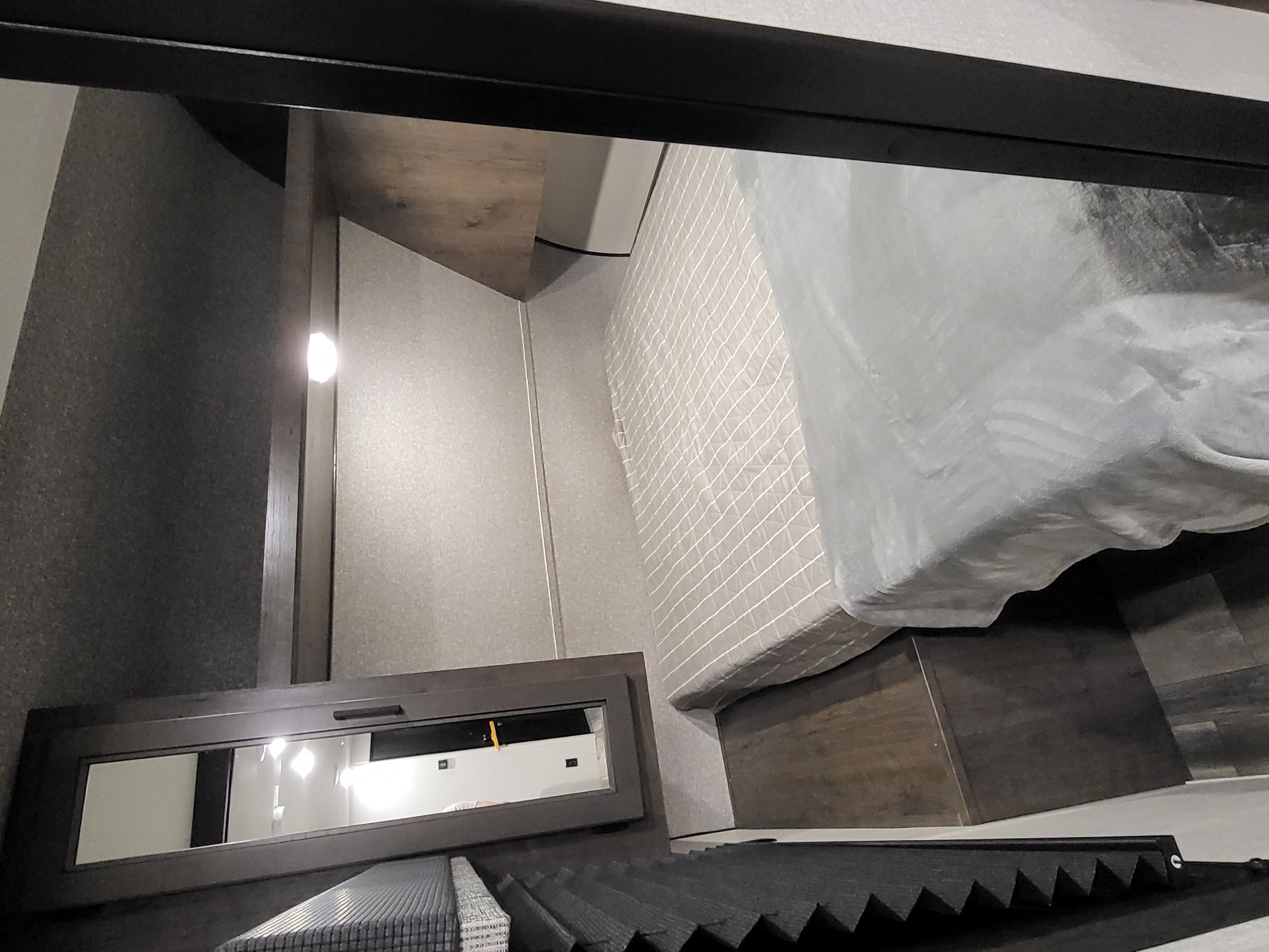 RV rental bedroom shows a compact sleeping area with quilted bed, built-in light, and window with blinds.. Starcraft Autumn Ridge 2022