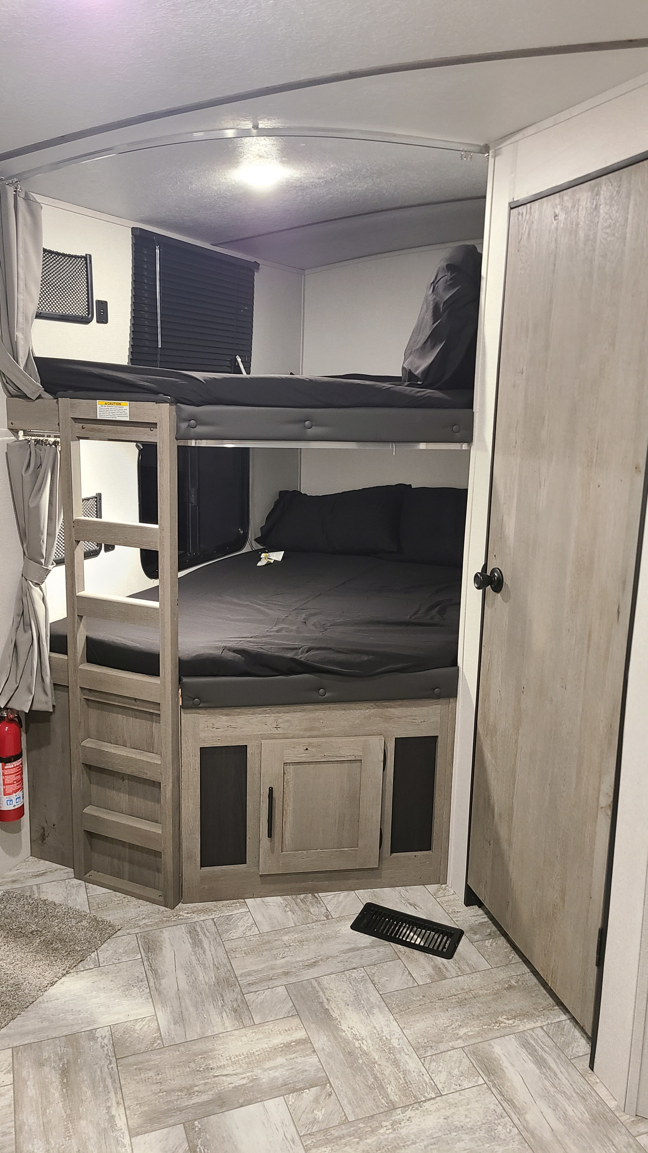 RV rental: dark gray bunk beds with a ladder, under-bed storage, and a fire extinguisher.. Keystone Springdale 2022