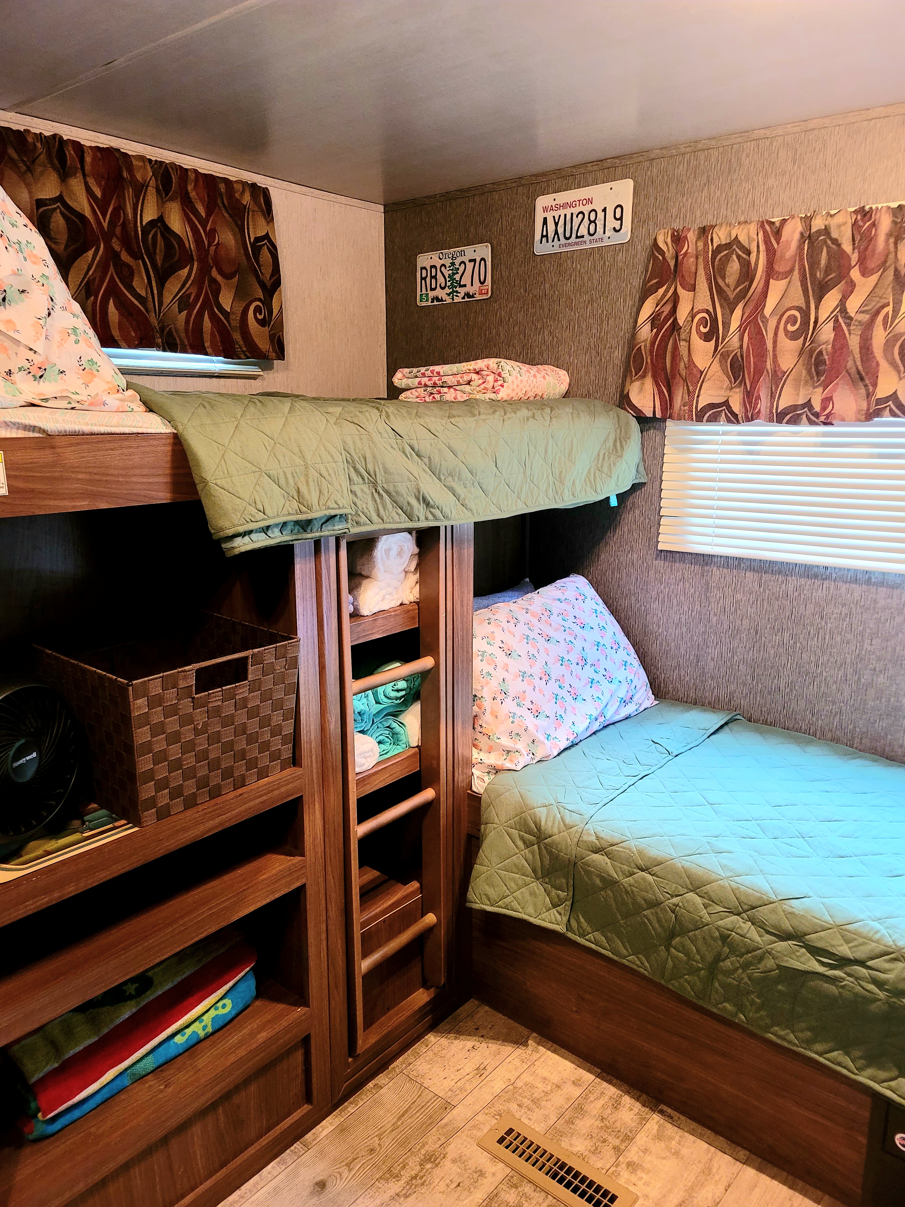 RV rental bunk beds: A compact and cozy sleeping area with built-in storage and unique wall decor.. Heartland RVs Pioneer 2019